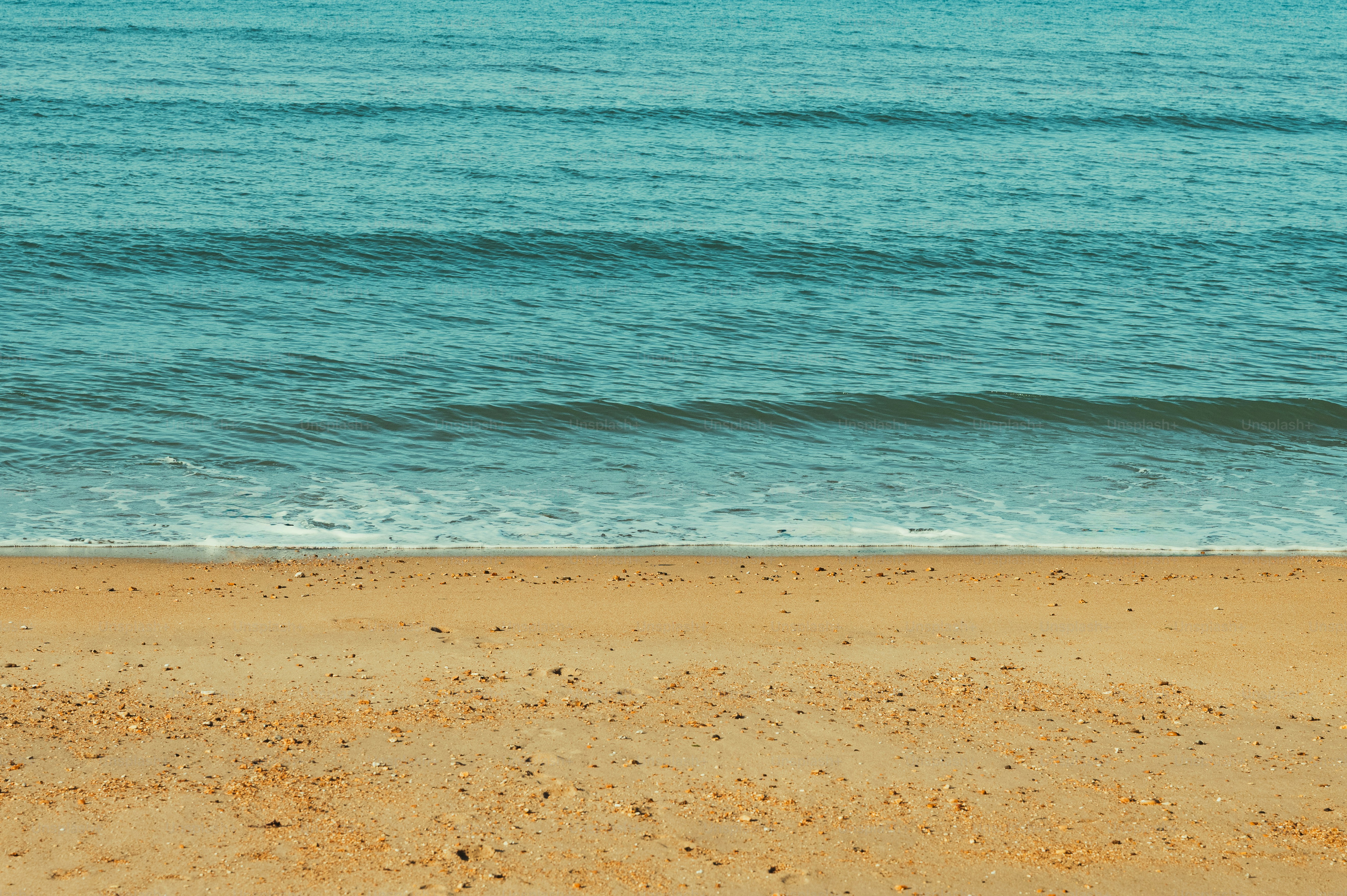 Sandy beach and calm blue ocean waves