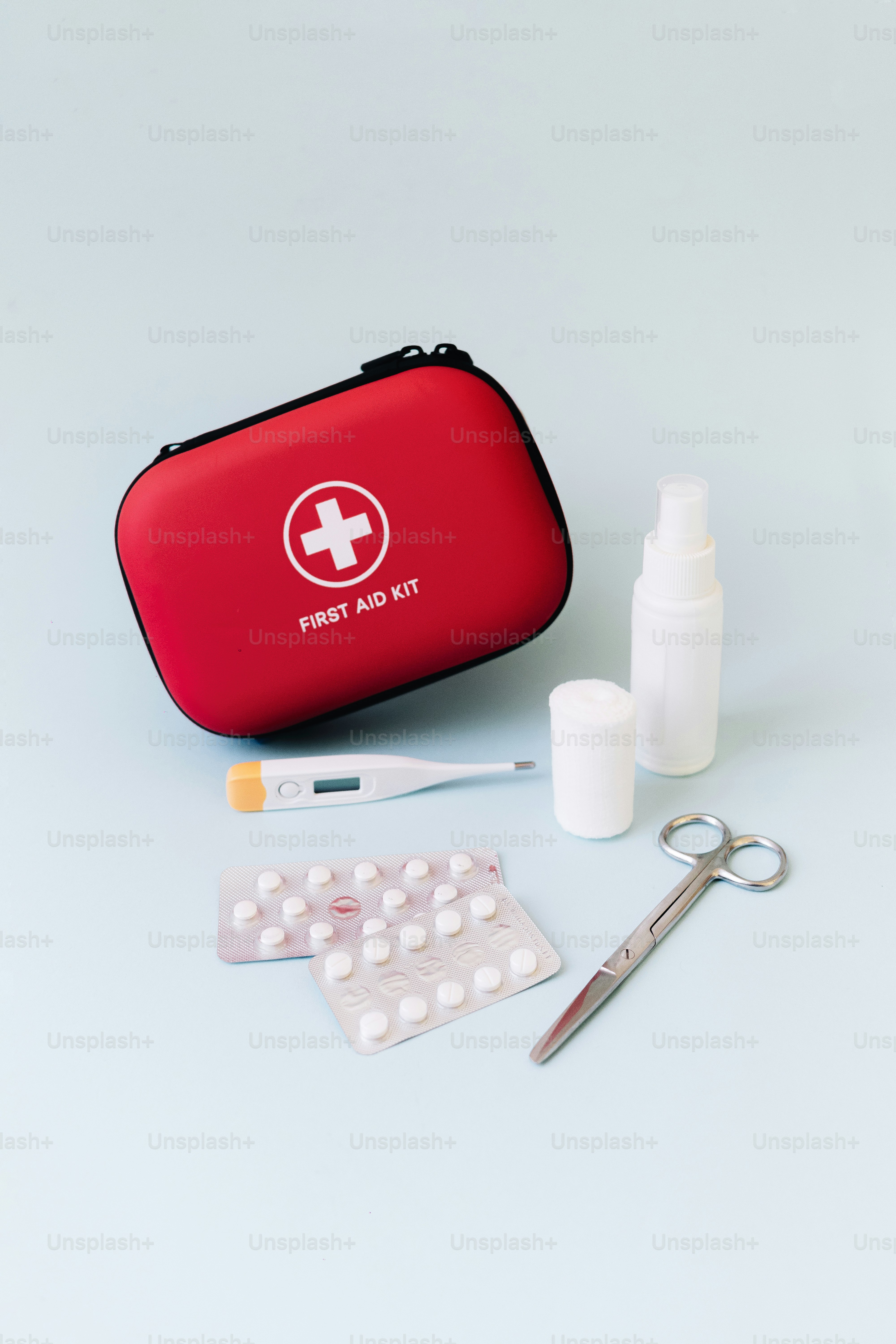 Erste-Hilfe-Kasten, Thermometer, Tabletten, Verbände und Schere