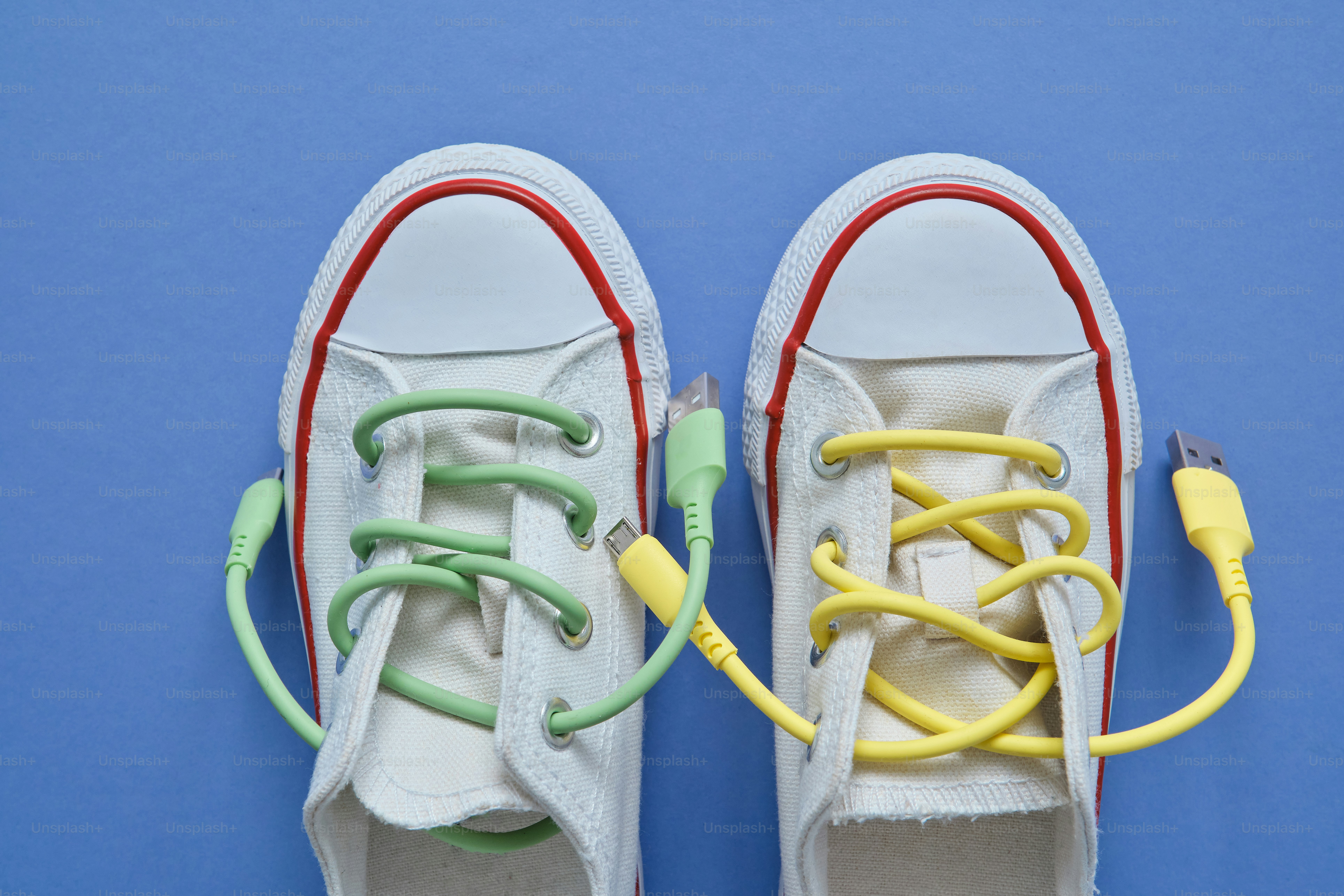 Zapatos de lona blanca con cables USB como cordones - Foto en Unsplash+