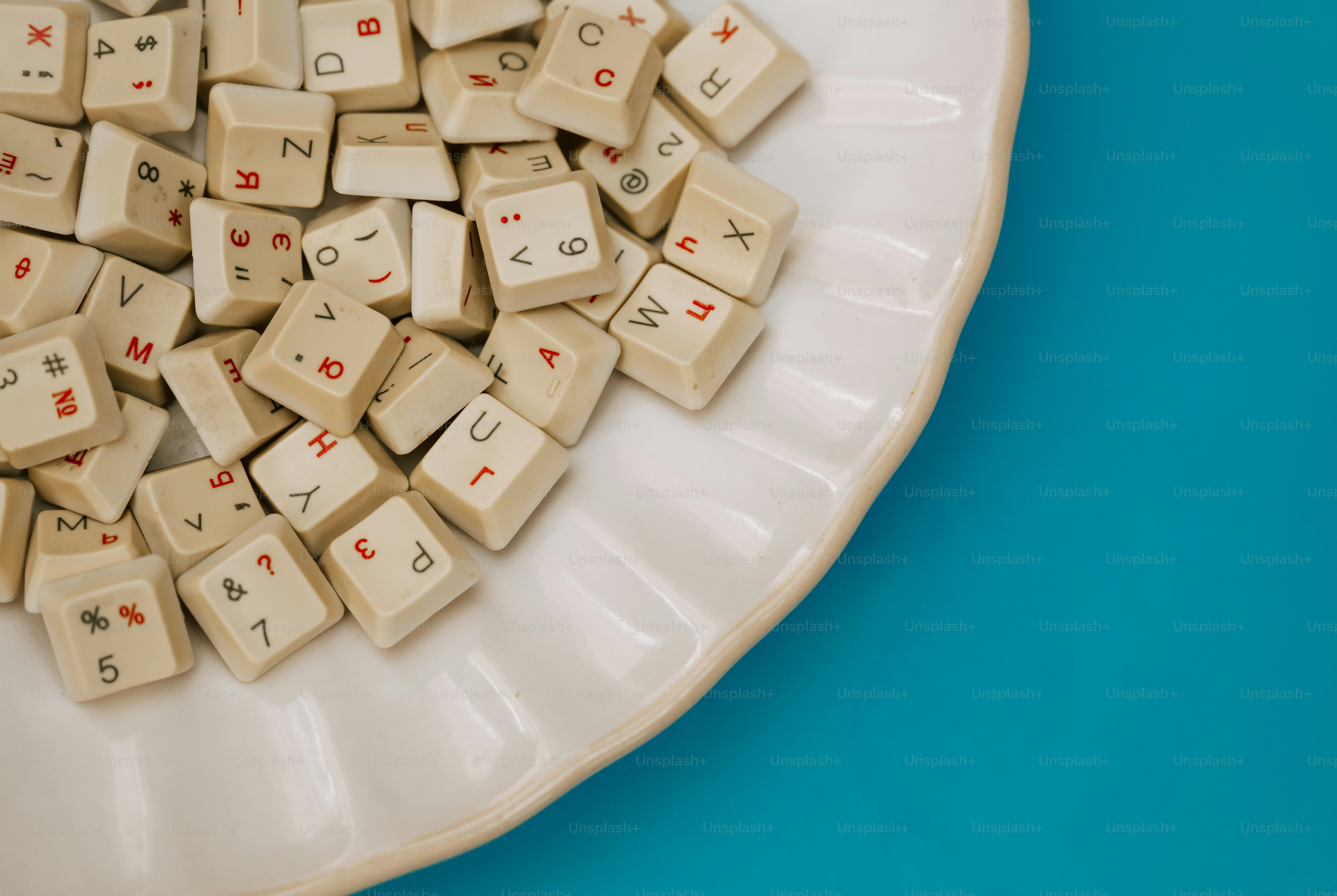 Piled vintage keyboard keys on a white plate