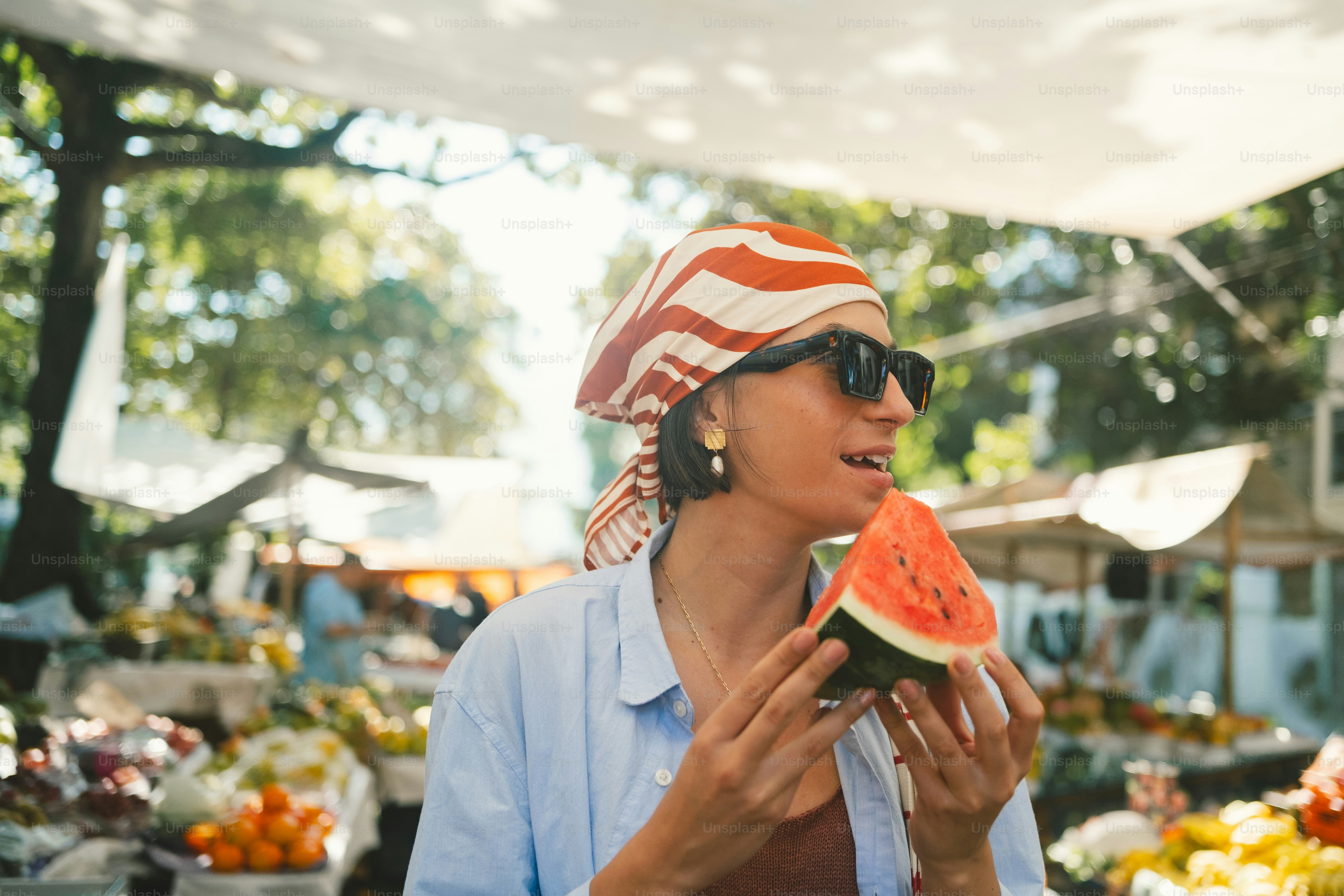 Woman eating watermelon at outdoor market