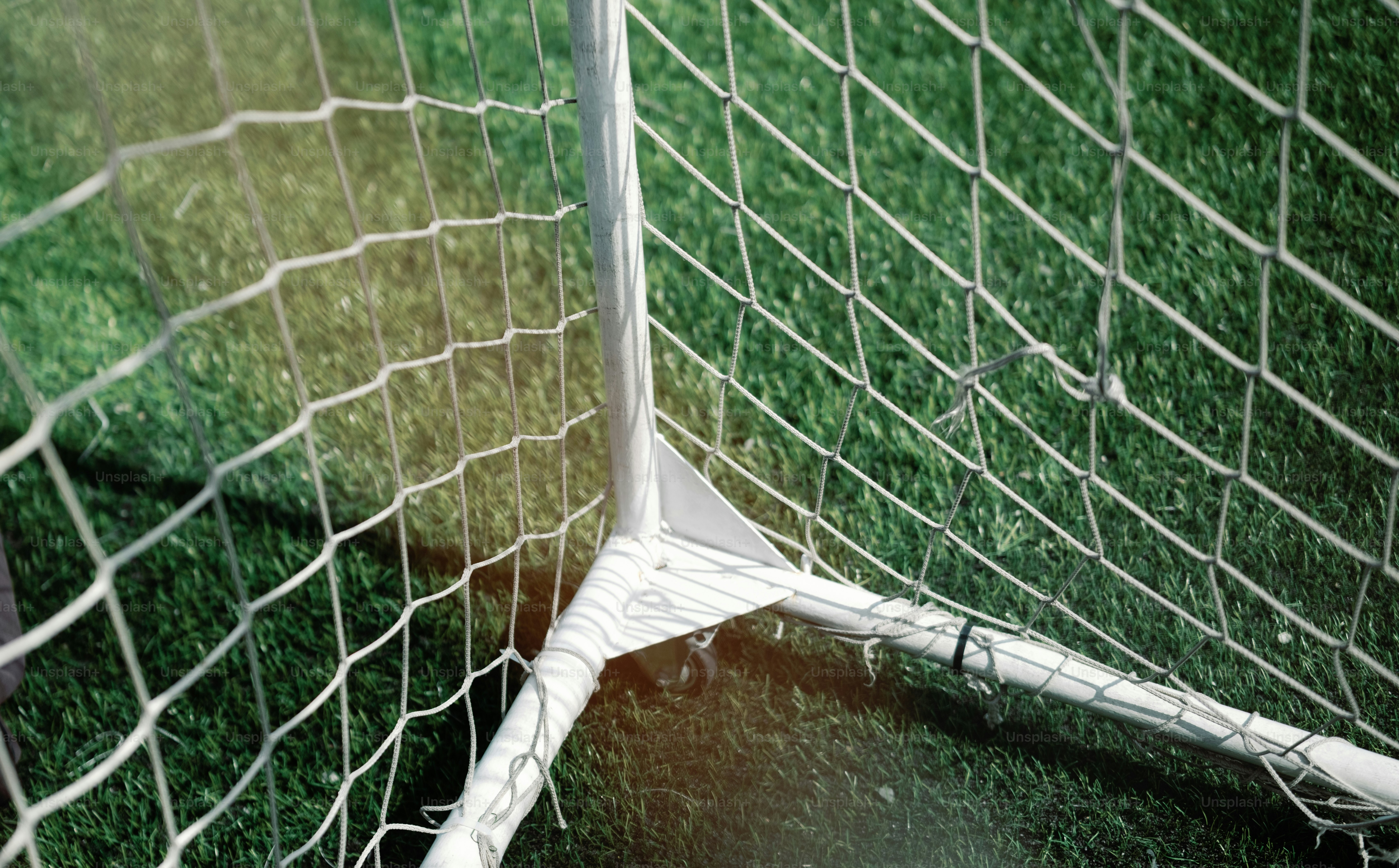 Gol branco de futebol e poste na grama