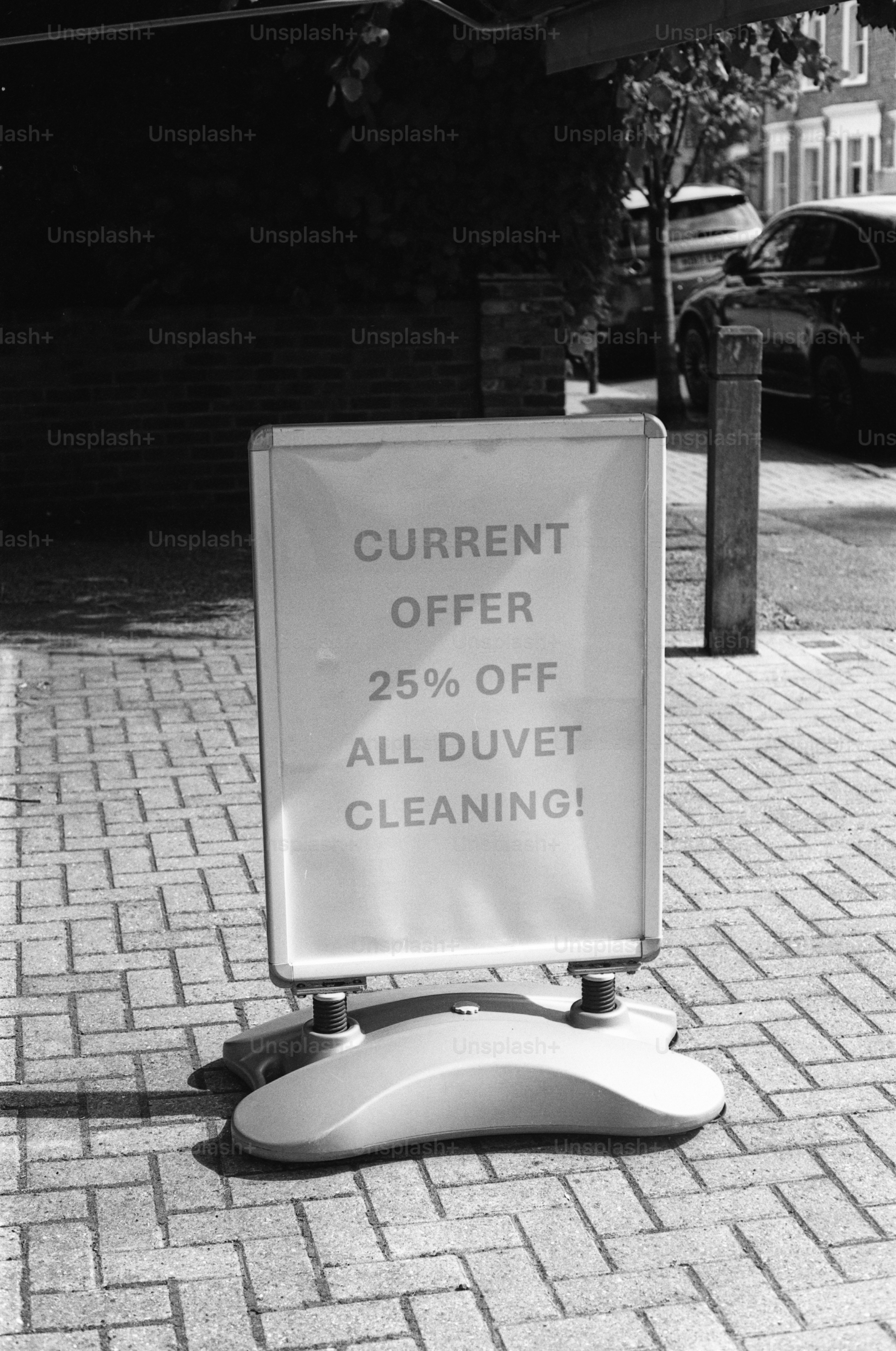 Placa de calçada anuncia 25% de desconto na limpeza de edredom