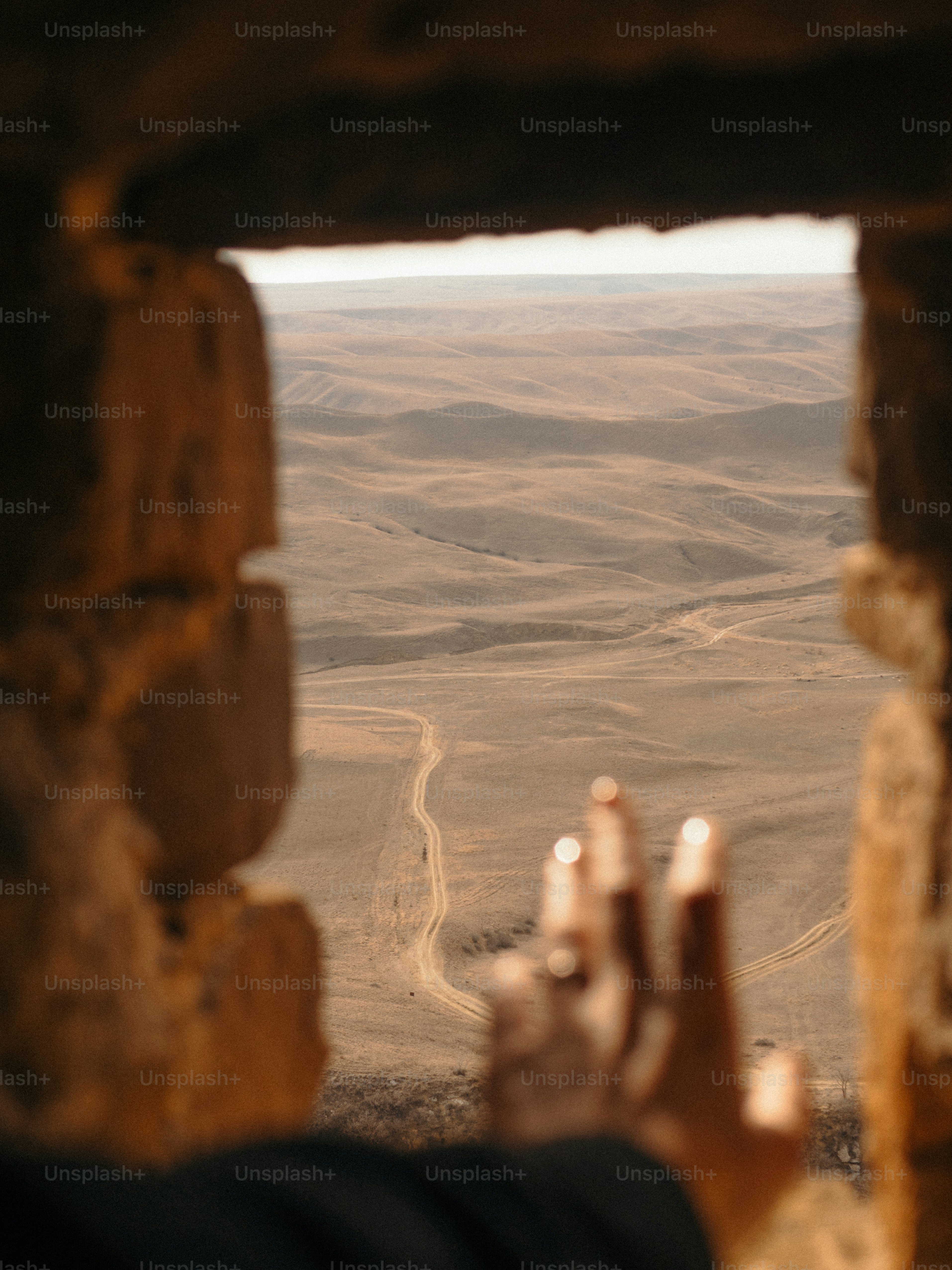 Hand frames view of dry, hilly landscape