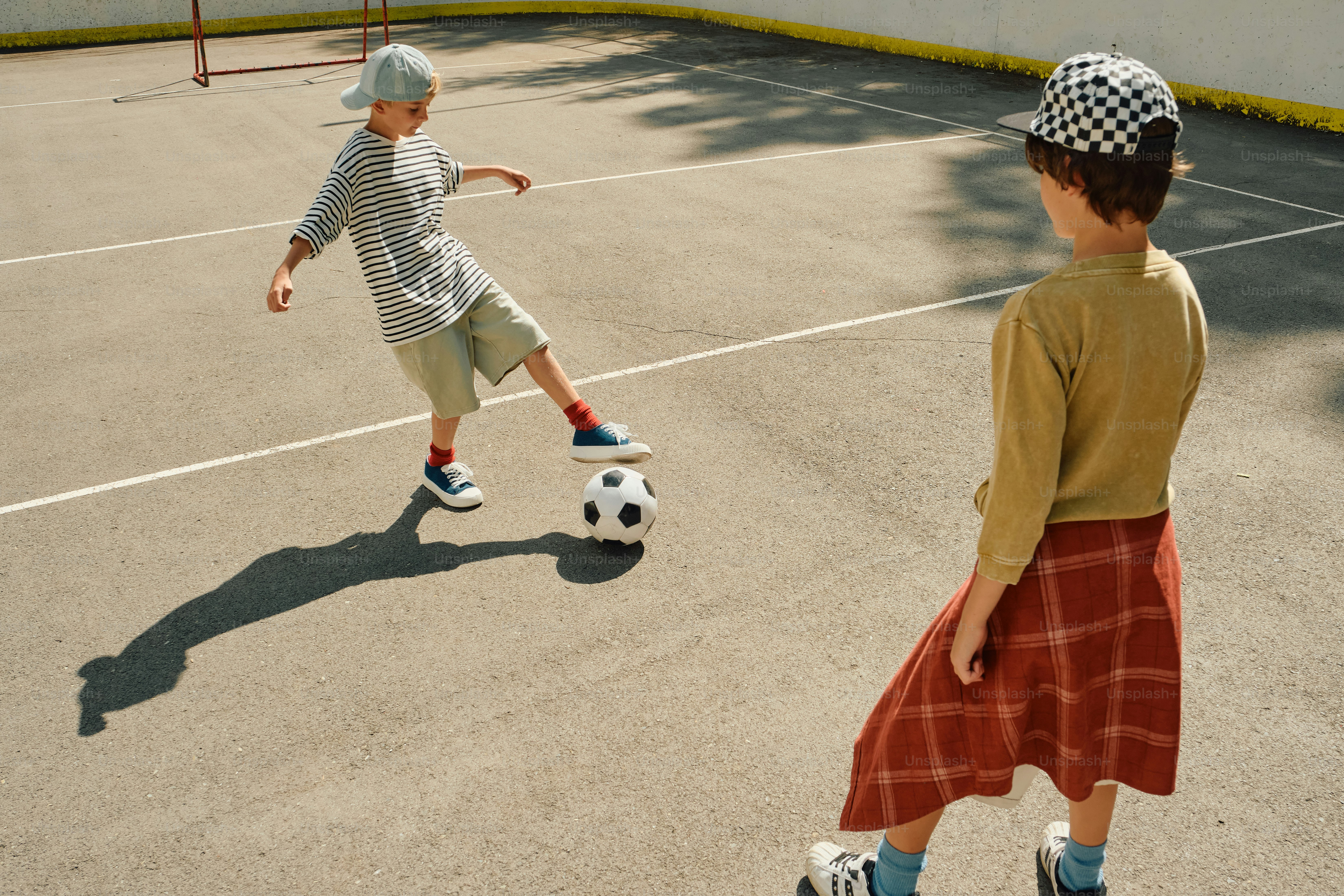 Children playing soccer on an outdoor court