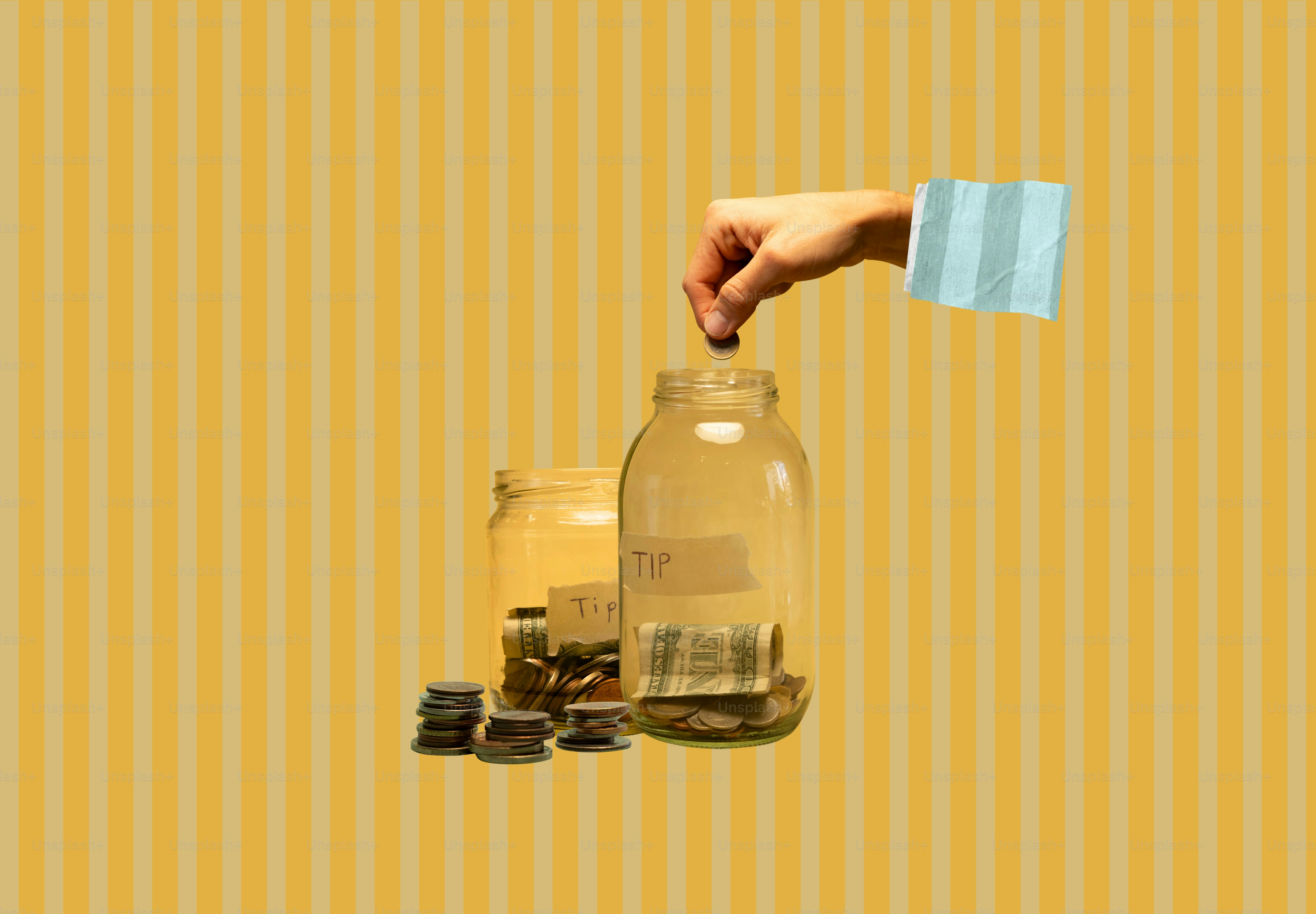 Hand dropping coin into glass jar of savings