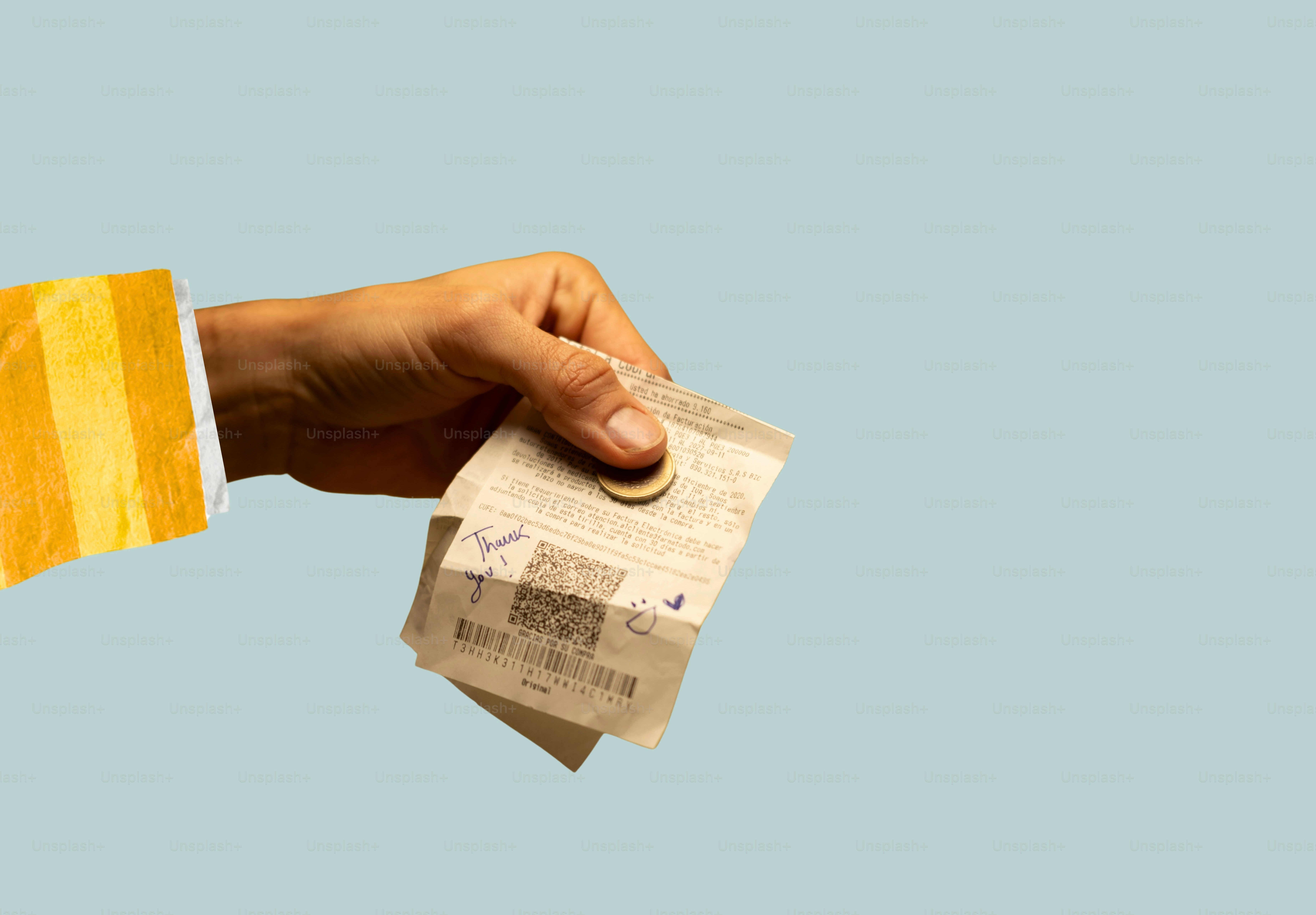 Hand with striped sleeve holding receipts and coin