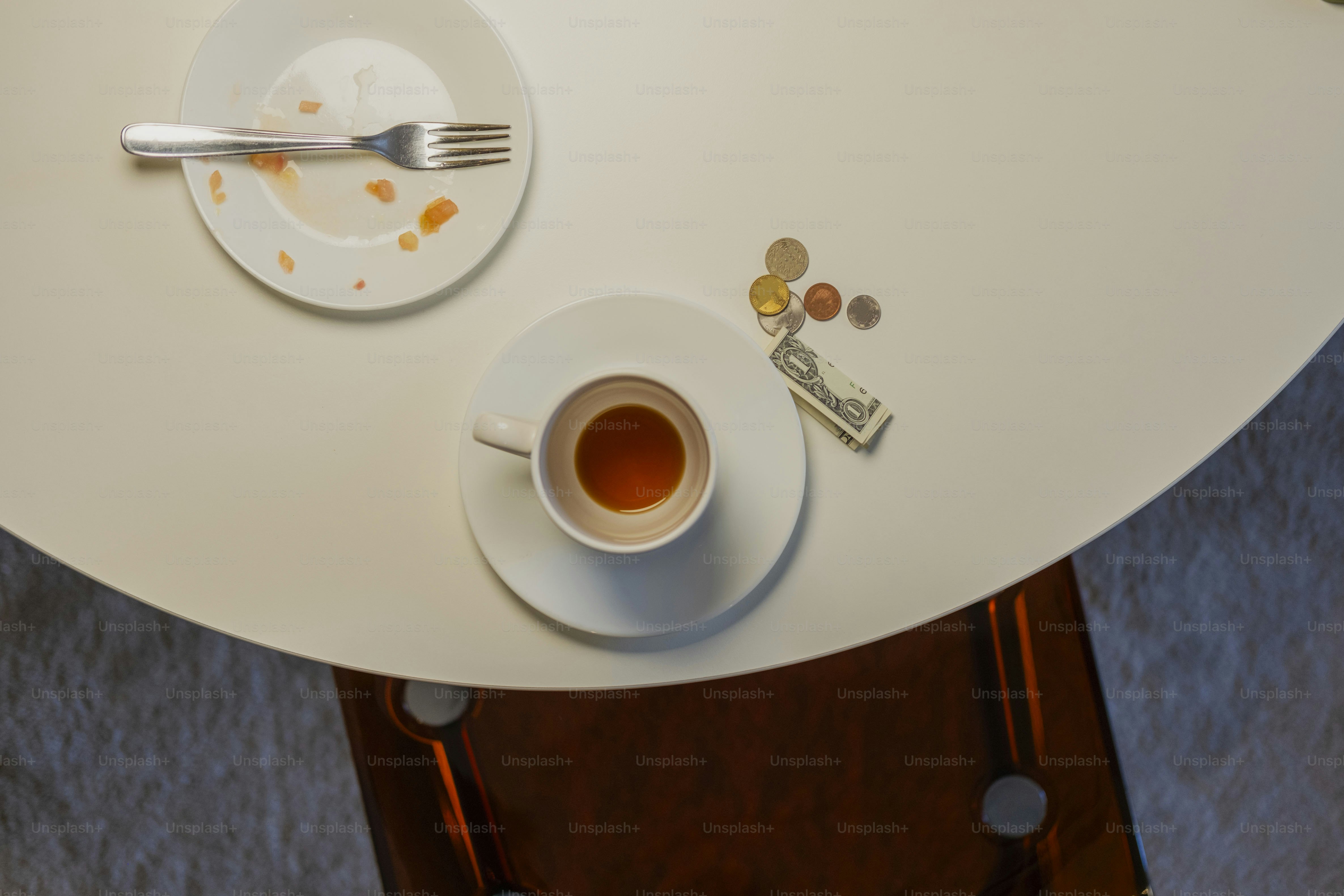Empty plate, coffee cup, money on table