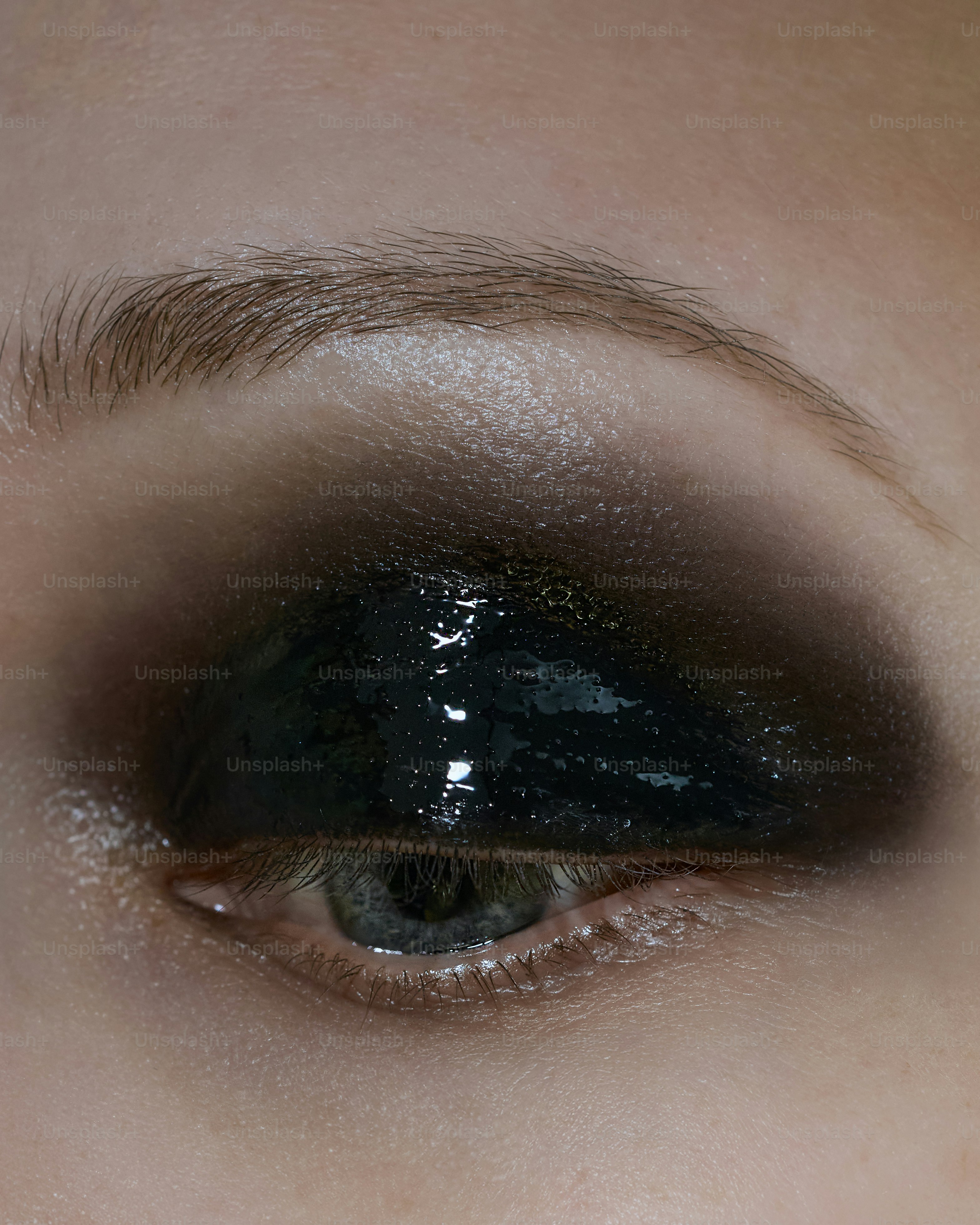 Eye with dramatic dark glossy eyeshadow