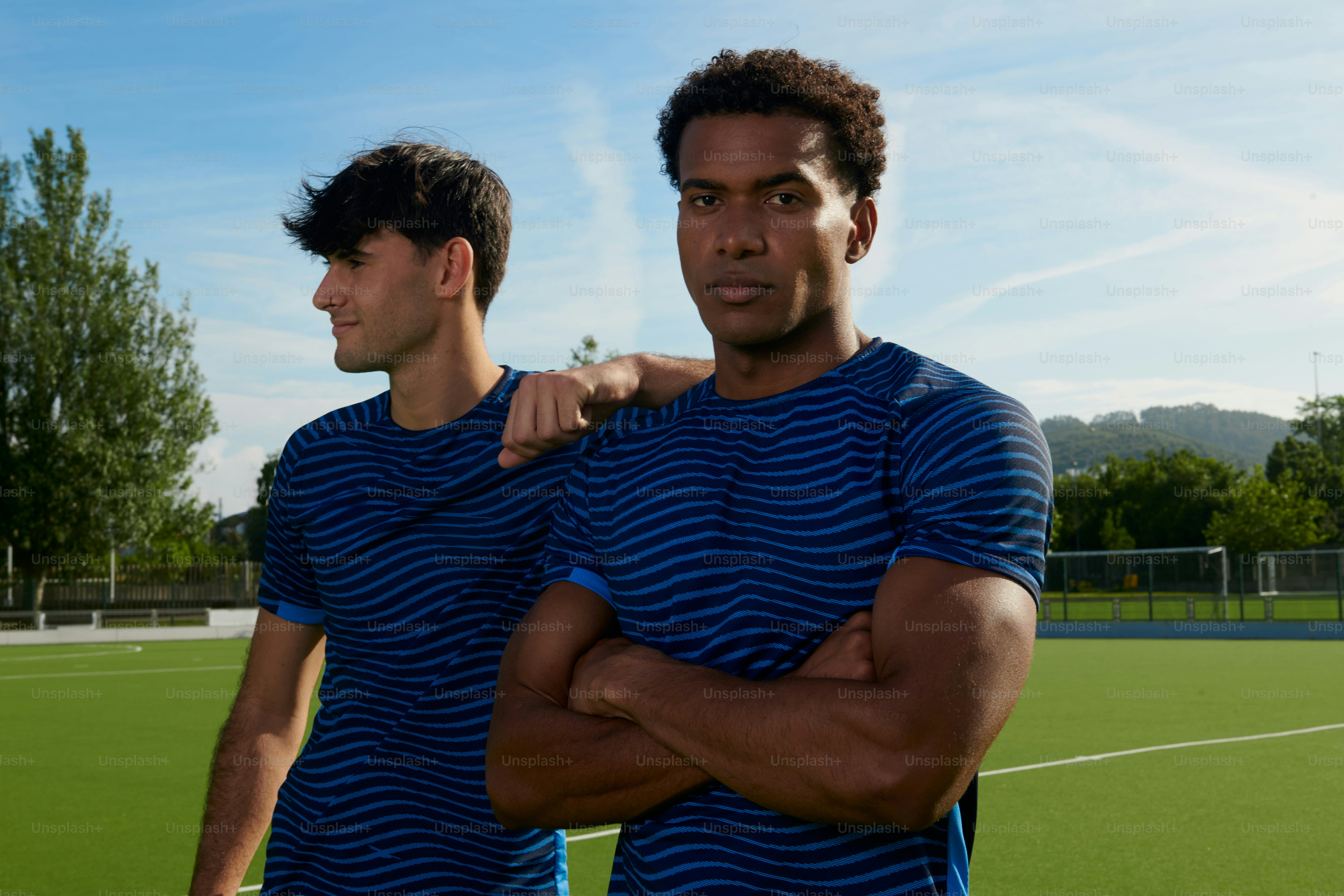 Des hommes en chemises rayées bleues sur un champ vert