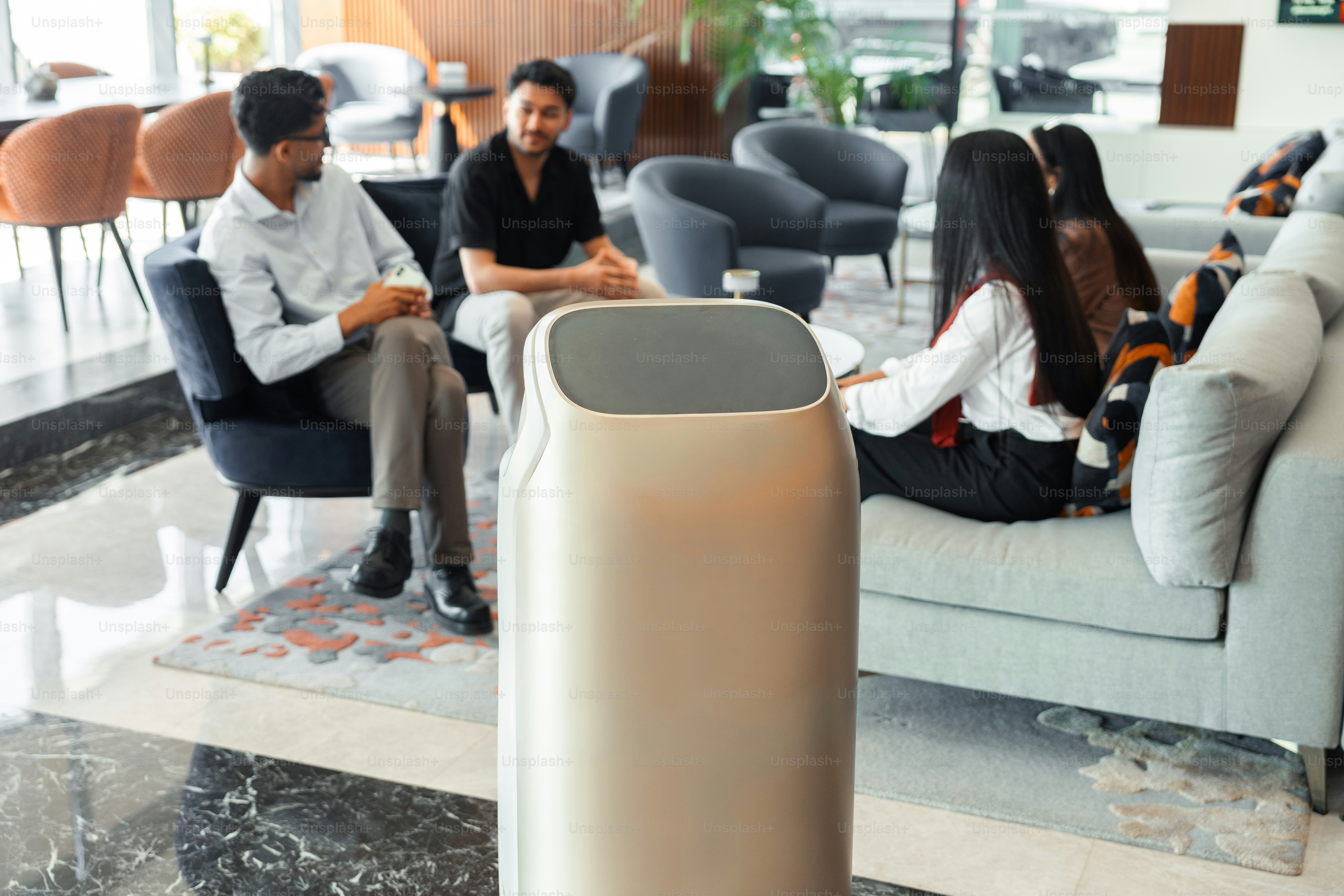 Robot di lounge modern dengan orang-orang yang bercakap-cakap