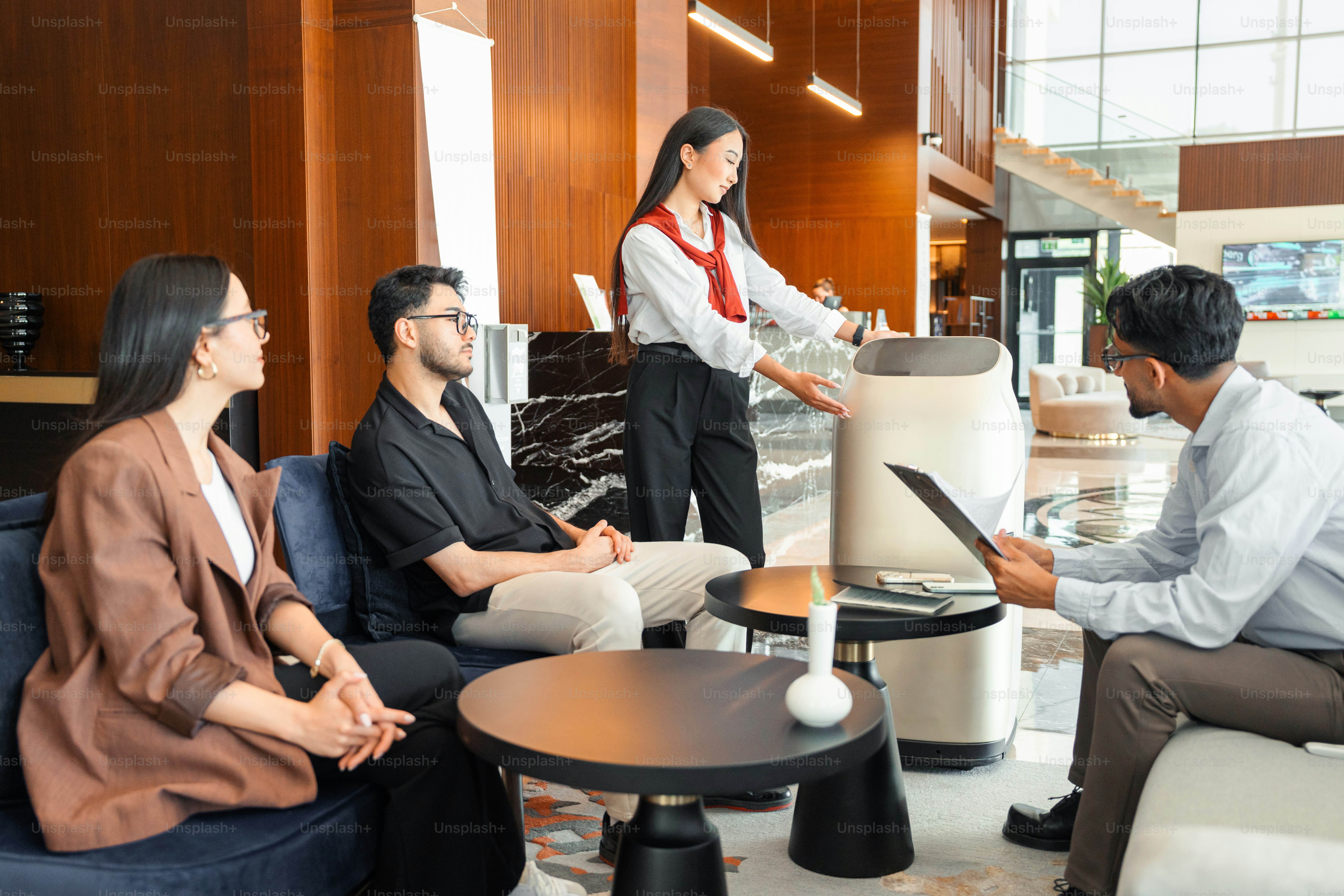 Staf hotel mendemonstrasikan robot servis di lobi modern