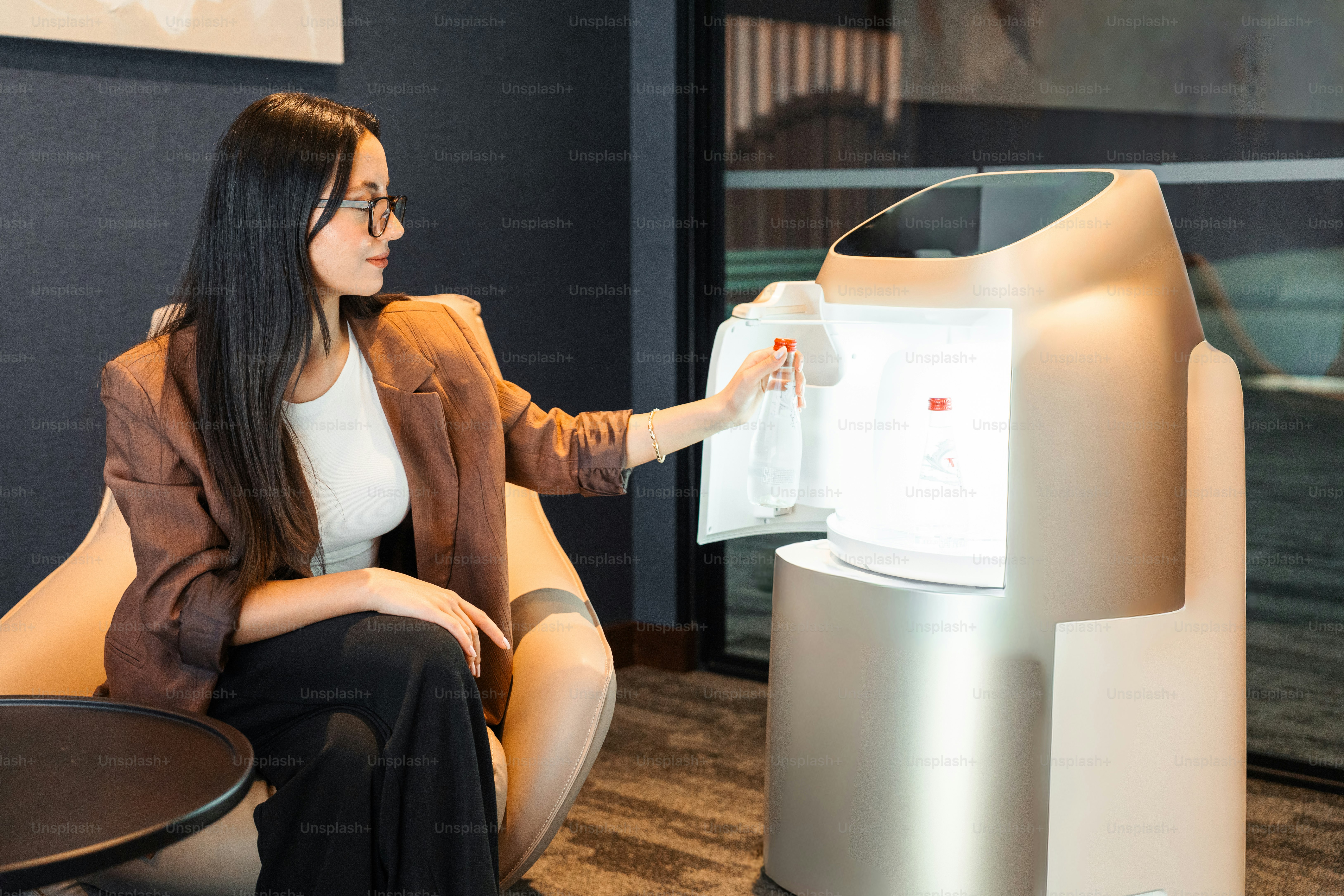 Wanita mengambil botol dari robot servis