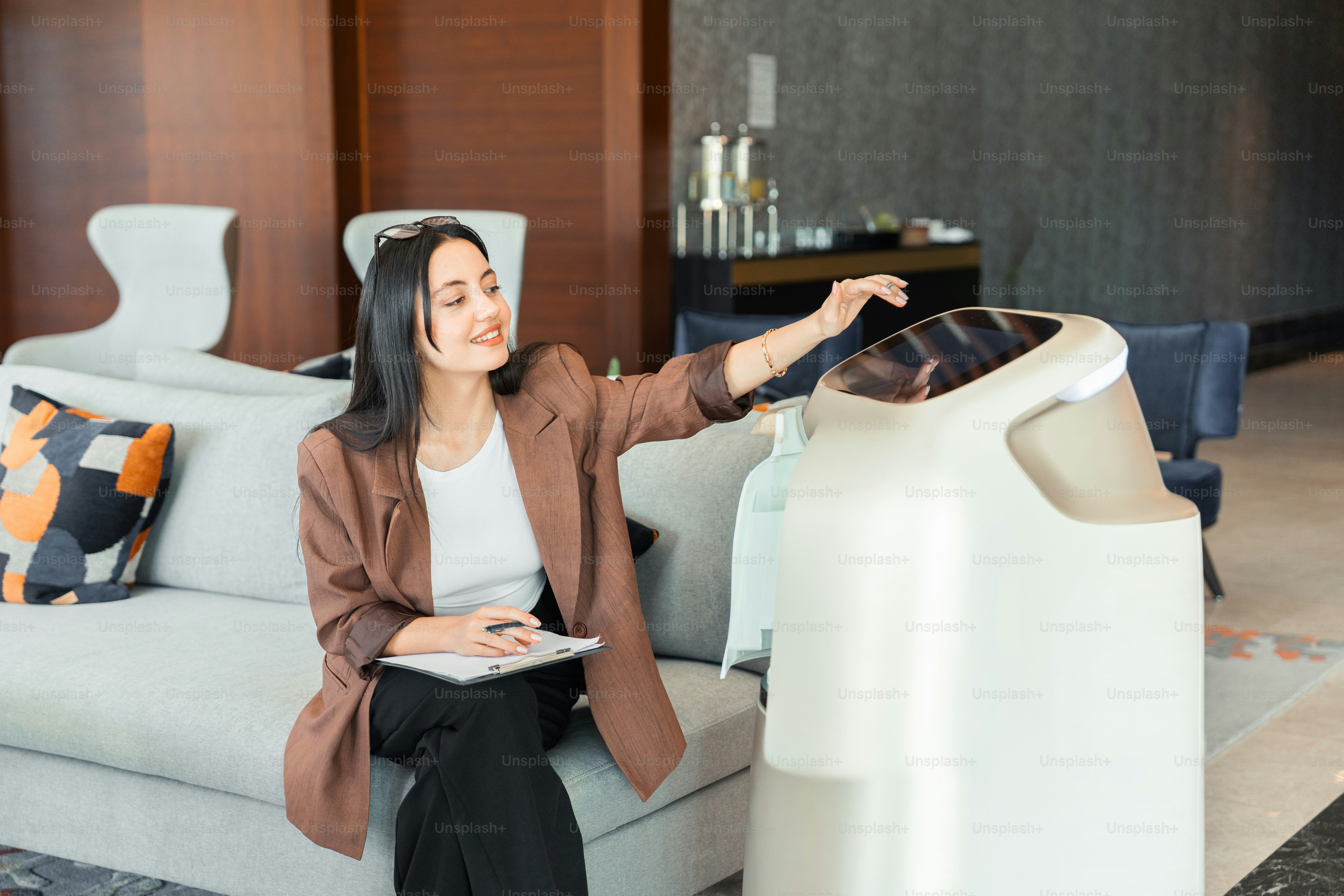 Wanita yang tersenyum berinteraksi dengan robot layanan futuristik
