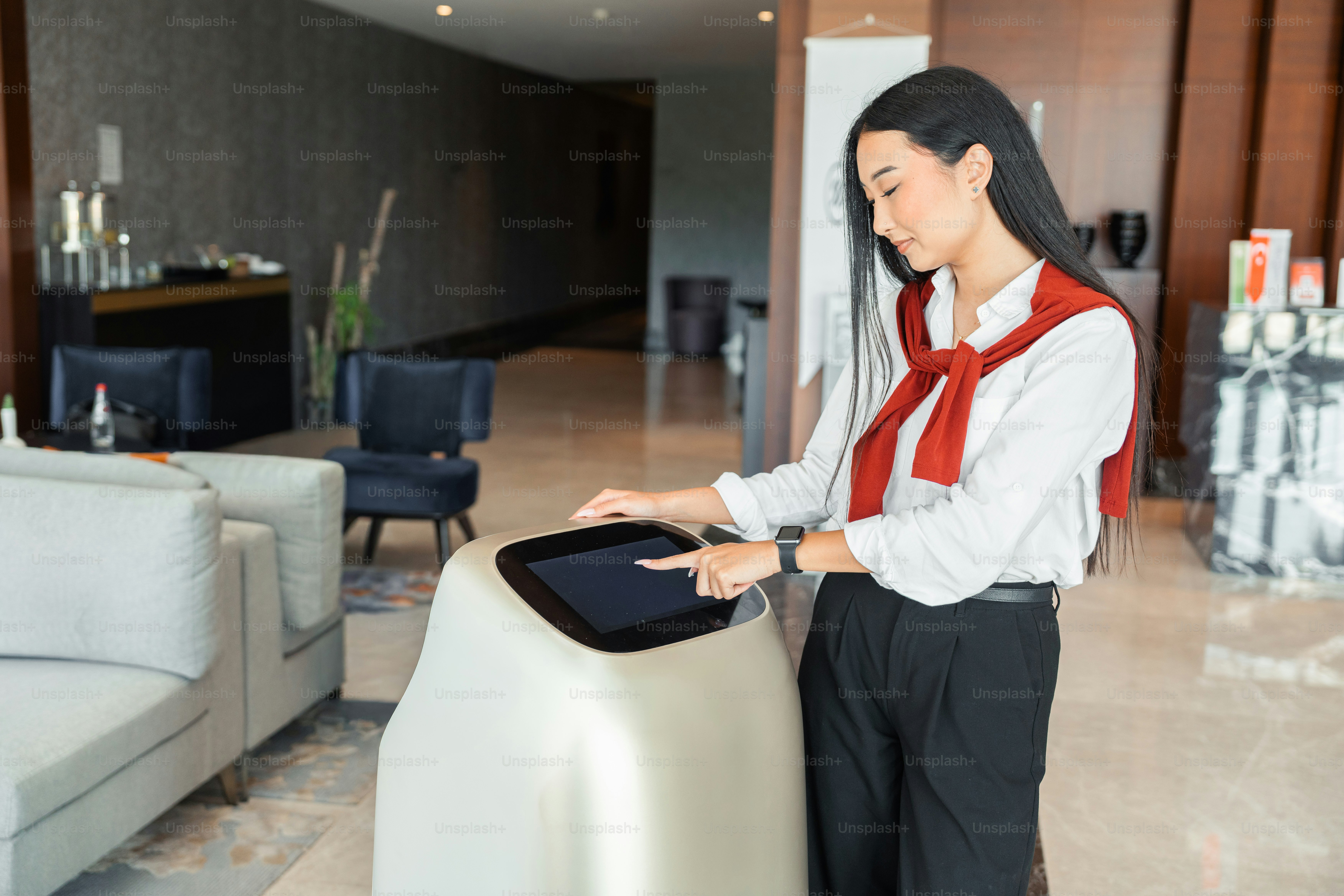 Wanita berinteraksi dengan robot layanan di lobi modern
