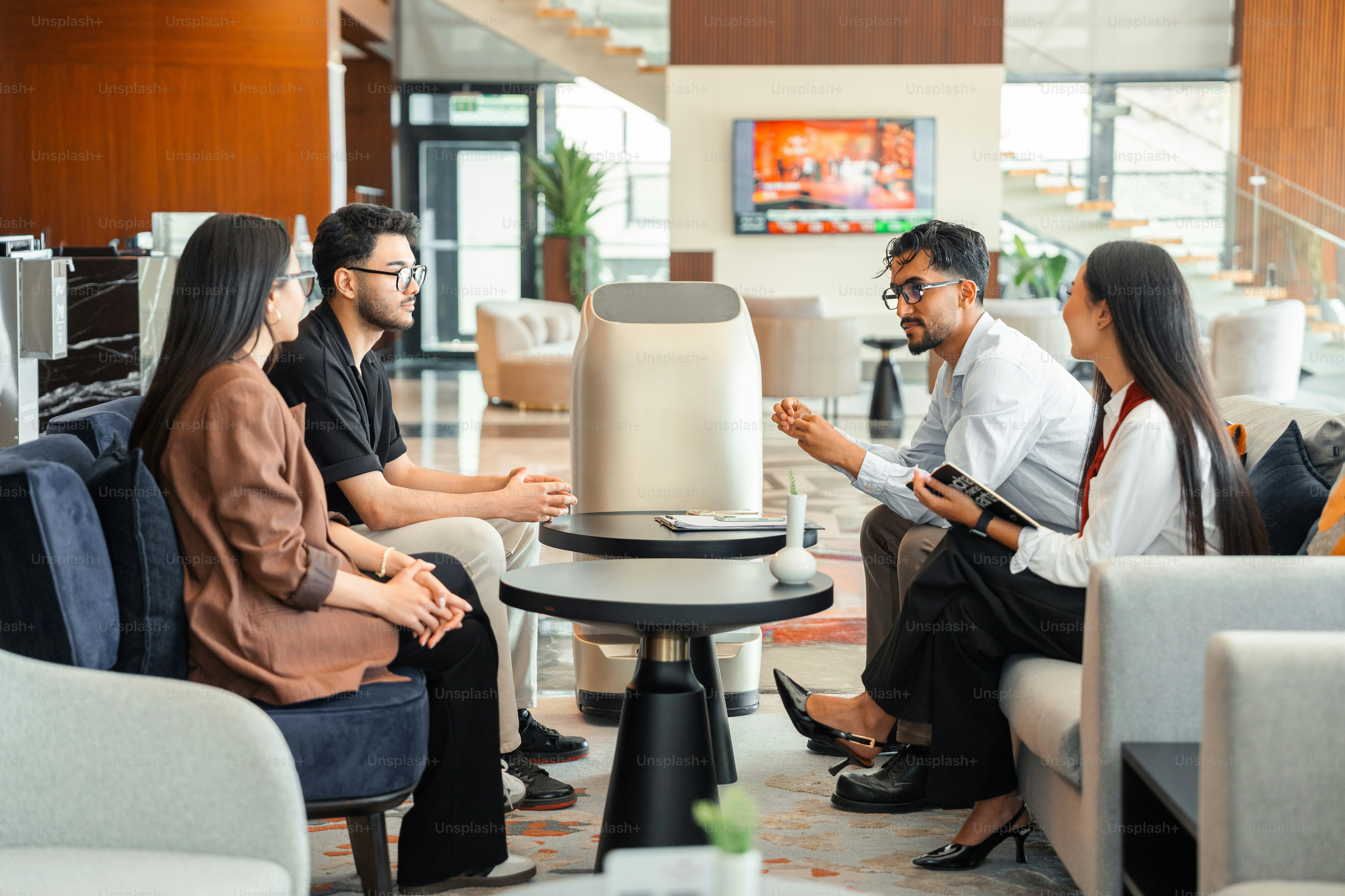 Empat pebisnis bertemu dengan robot di lounge