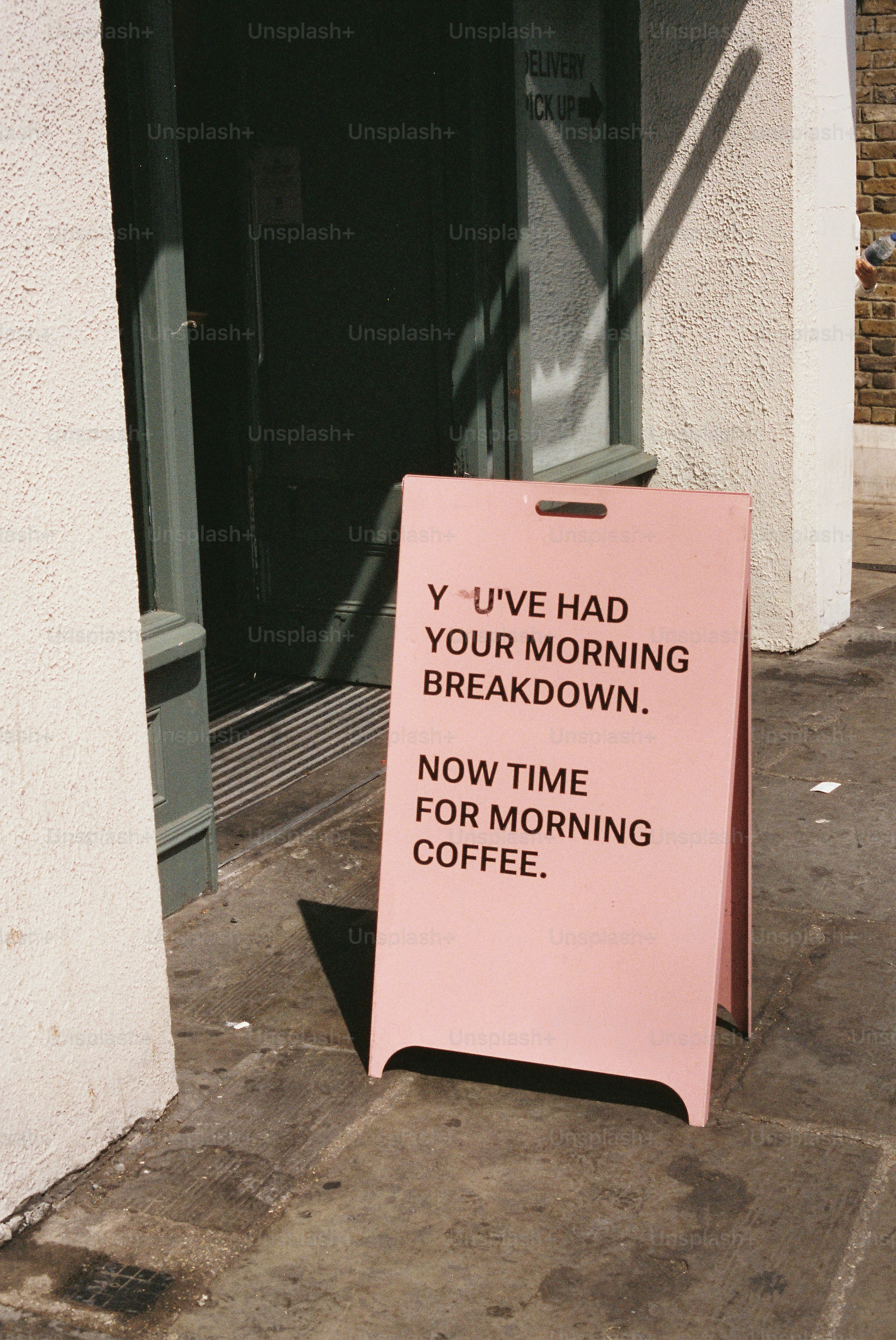 Humorous pink coffee sign outside a building