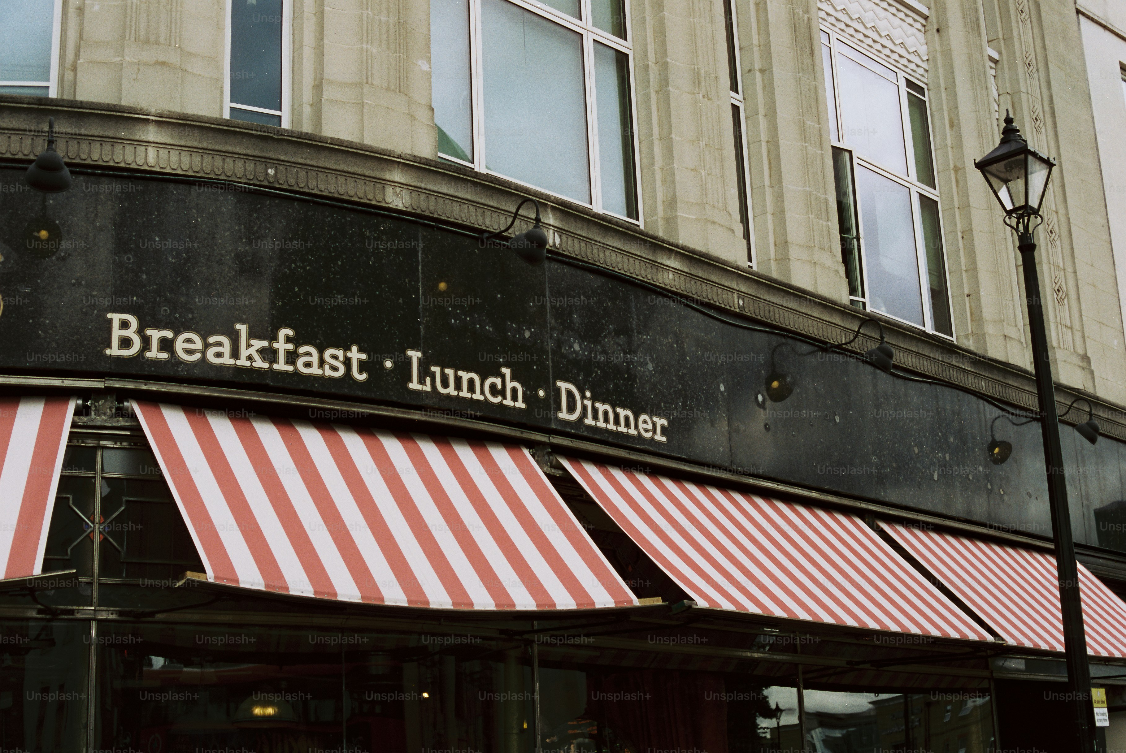 Breakfast lunch dinner sign above red striped awnings