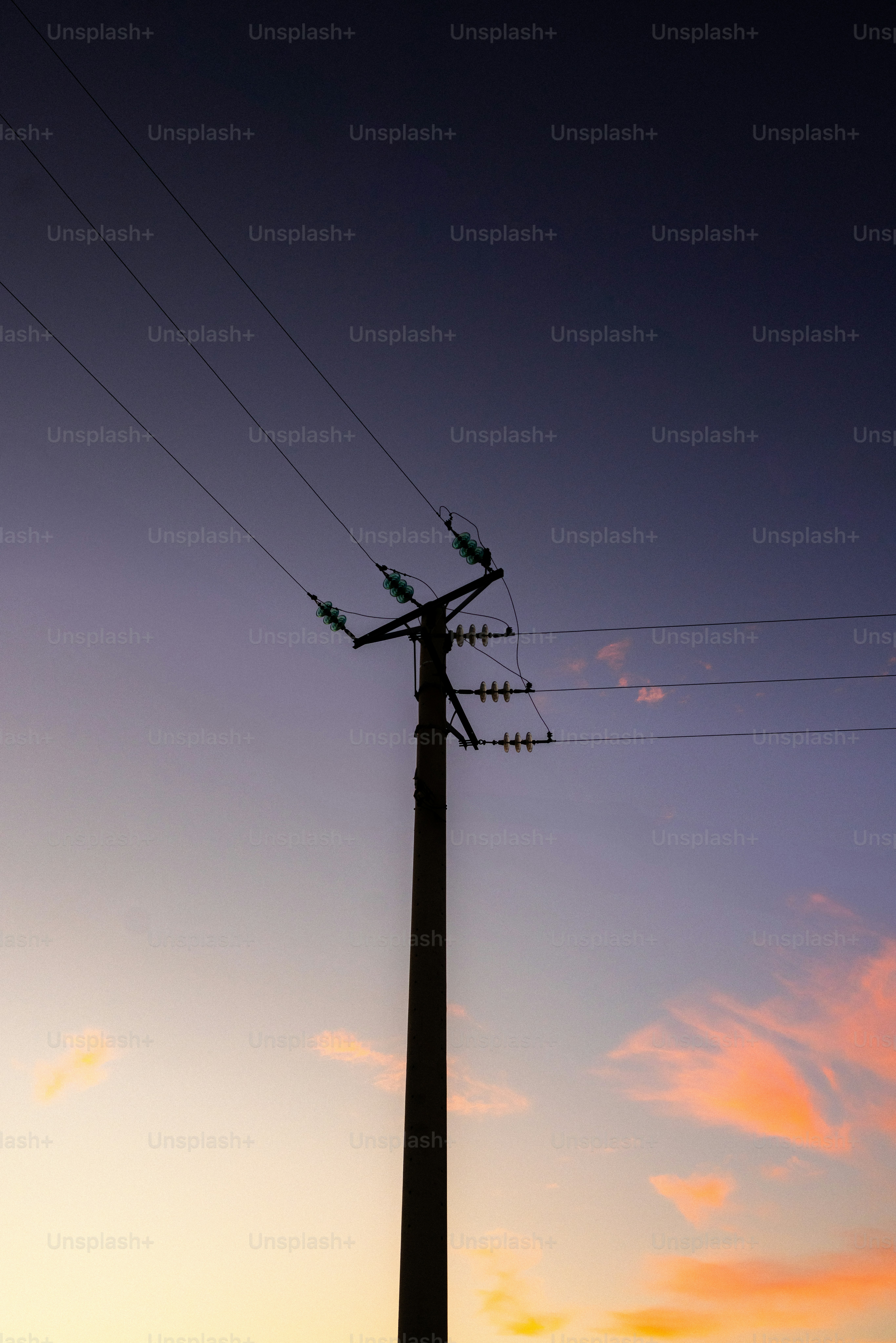 Silhueta de um poste de energia ao pôr do sol