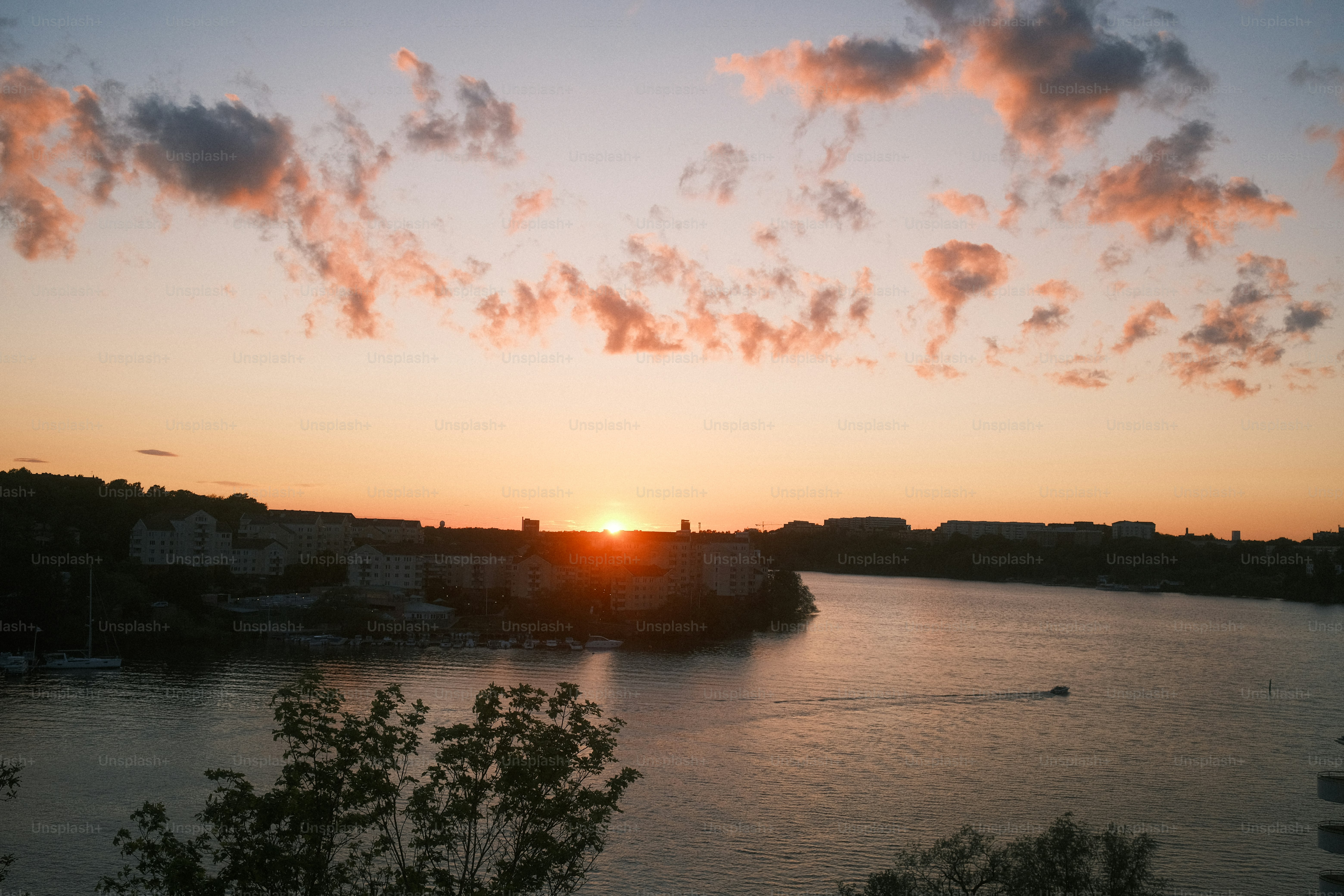 ストックホルムの海岸沿いの街景に金色の夕焼け