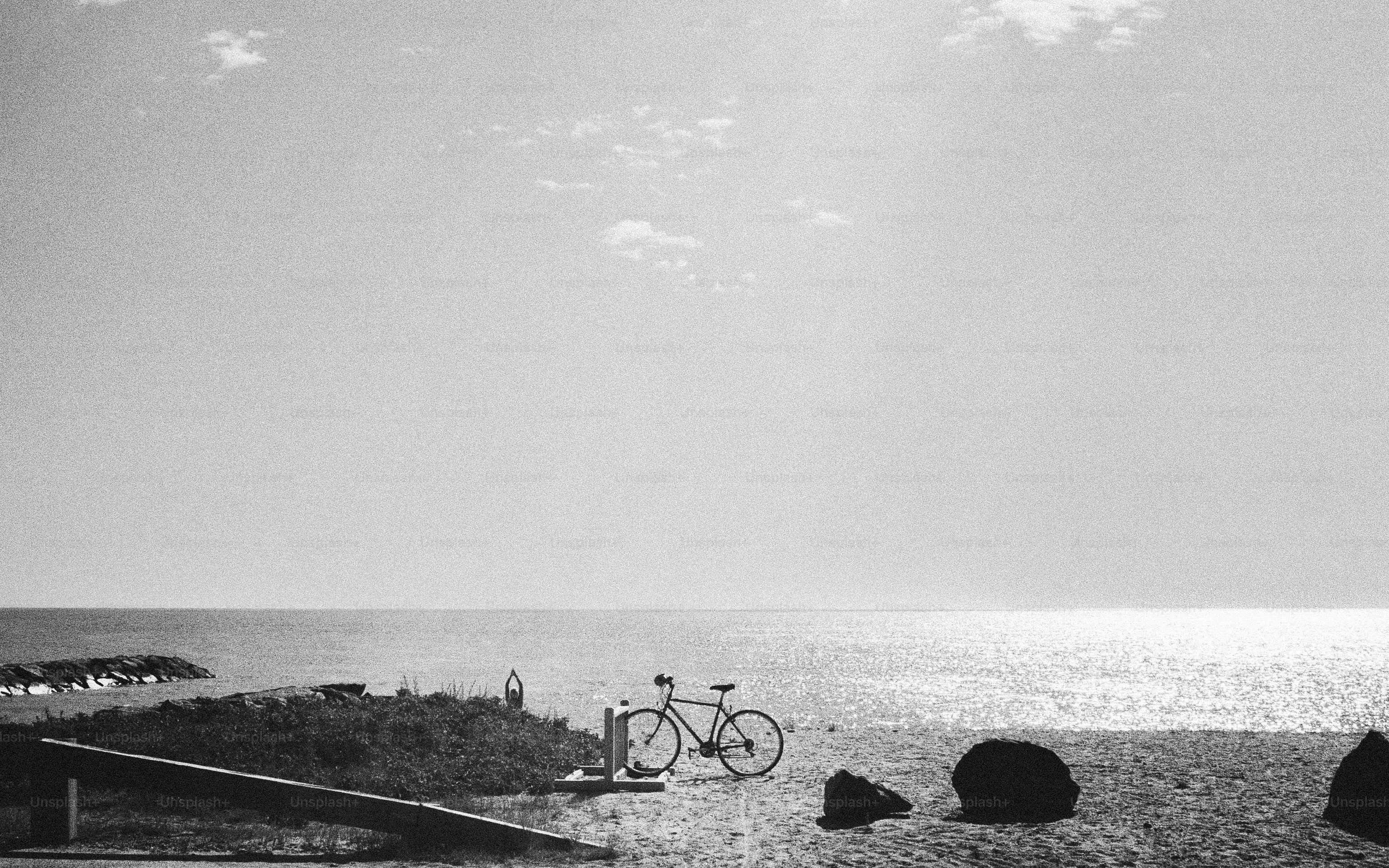 Bicicleta estacionada à beira do oceano sob um céu claro