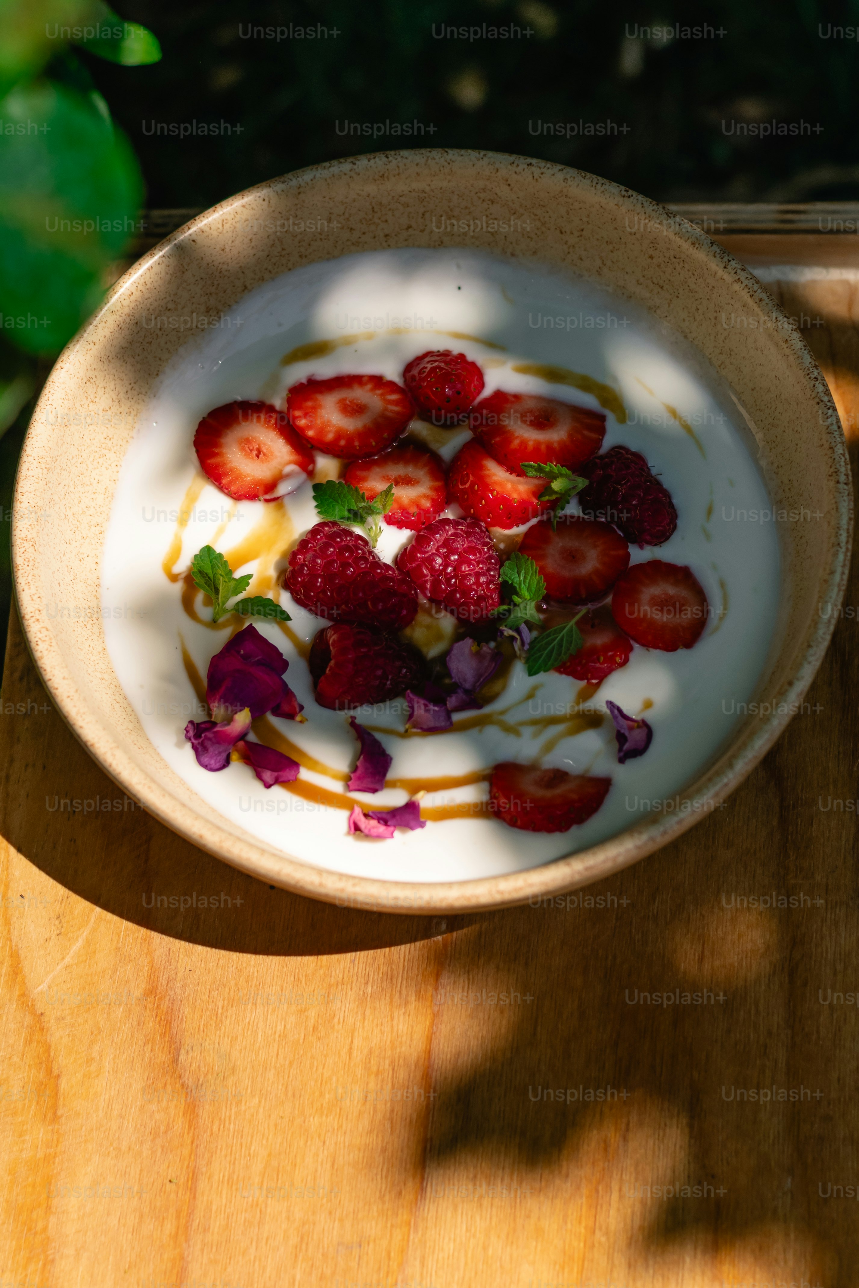 Yogurt with strawberries, raspberries, mint, and rose petals