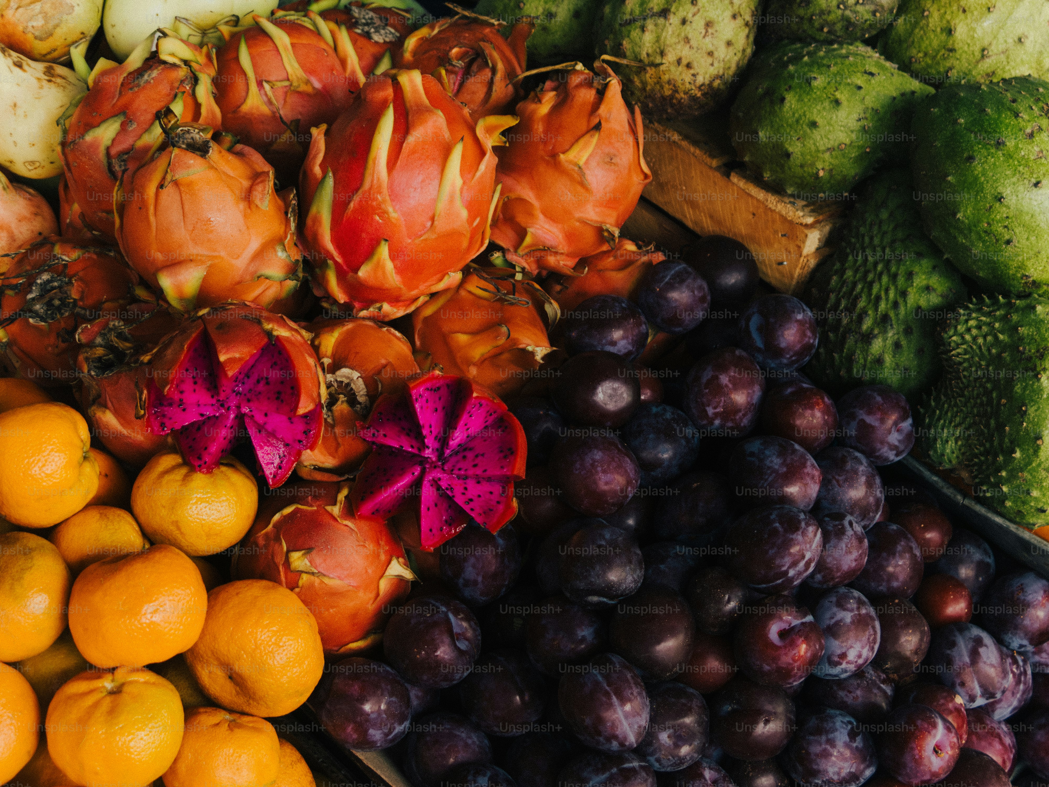 Frutas tropicales frescas: pitaya dragón, ciruelas, mandarinas
