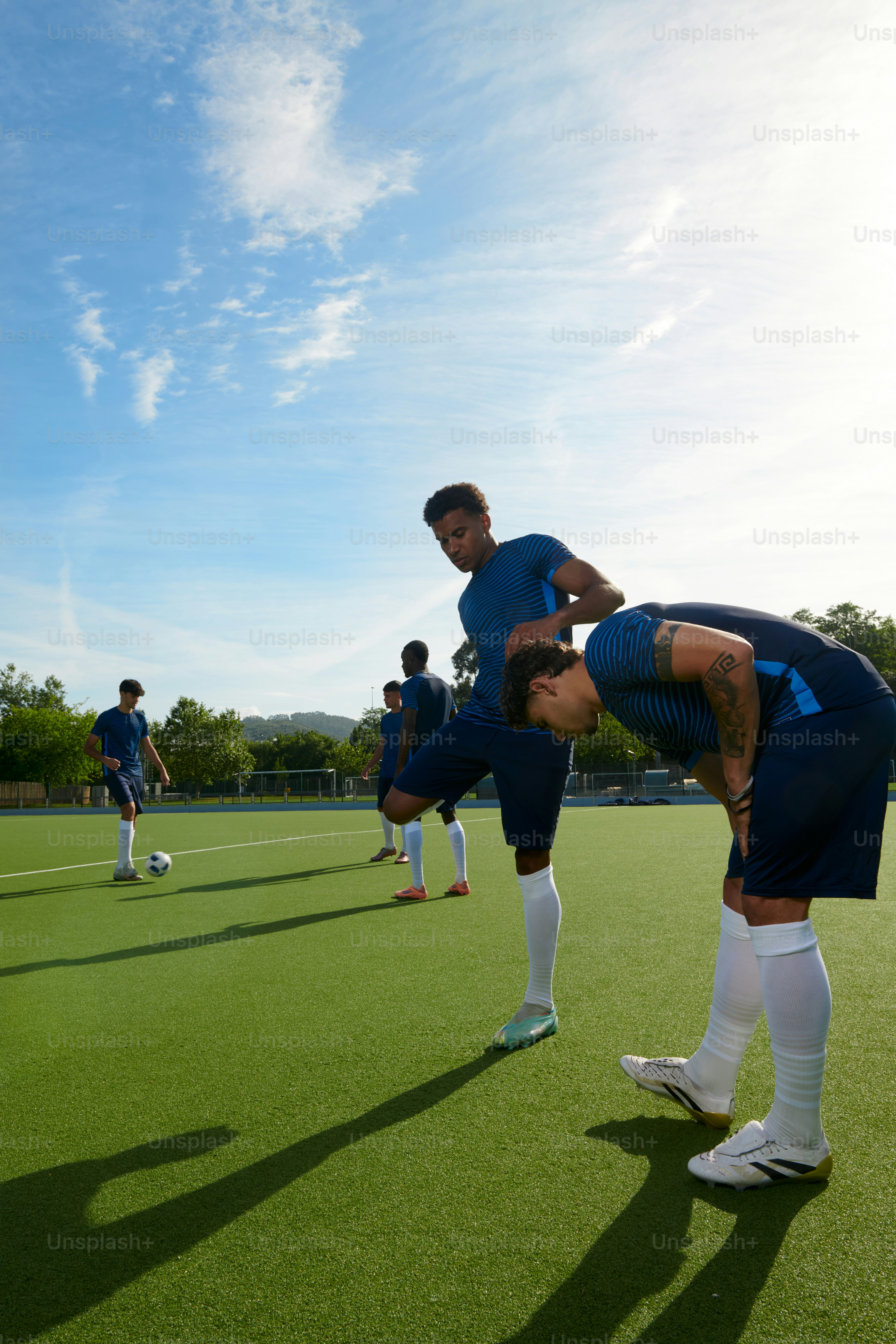 Männliche Fußballspieler, die sich auf einem grünen Feld ausstrecken