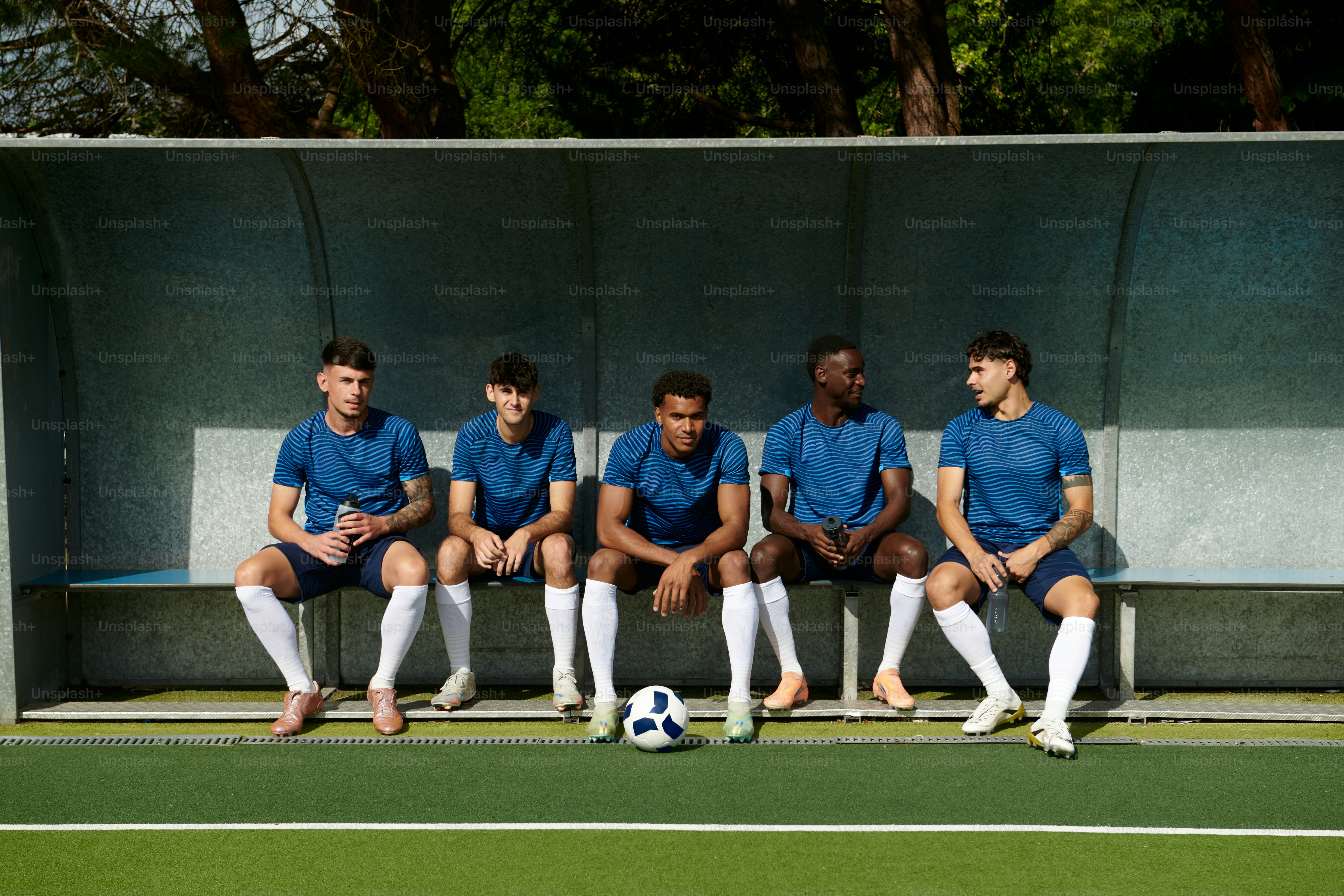 Fußballspieler sitzen auf einer Mannschaftsbank