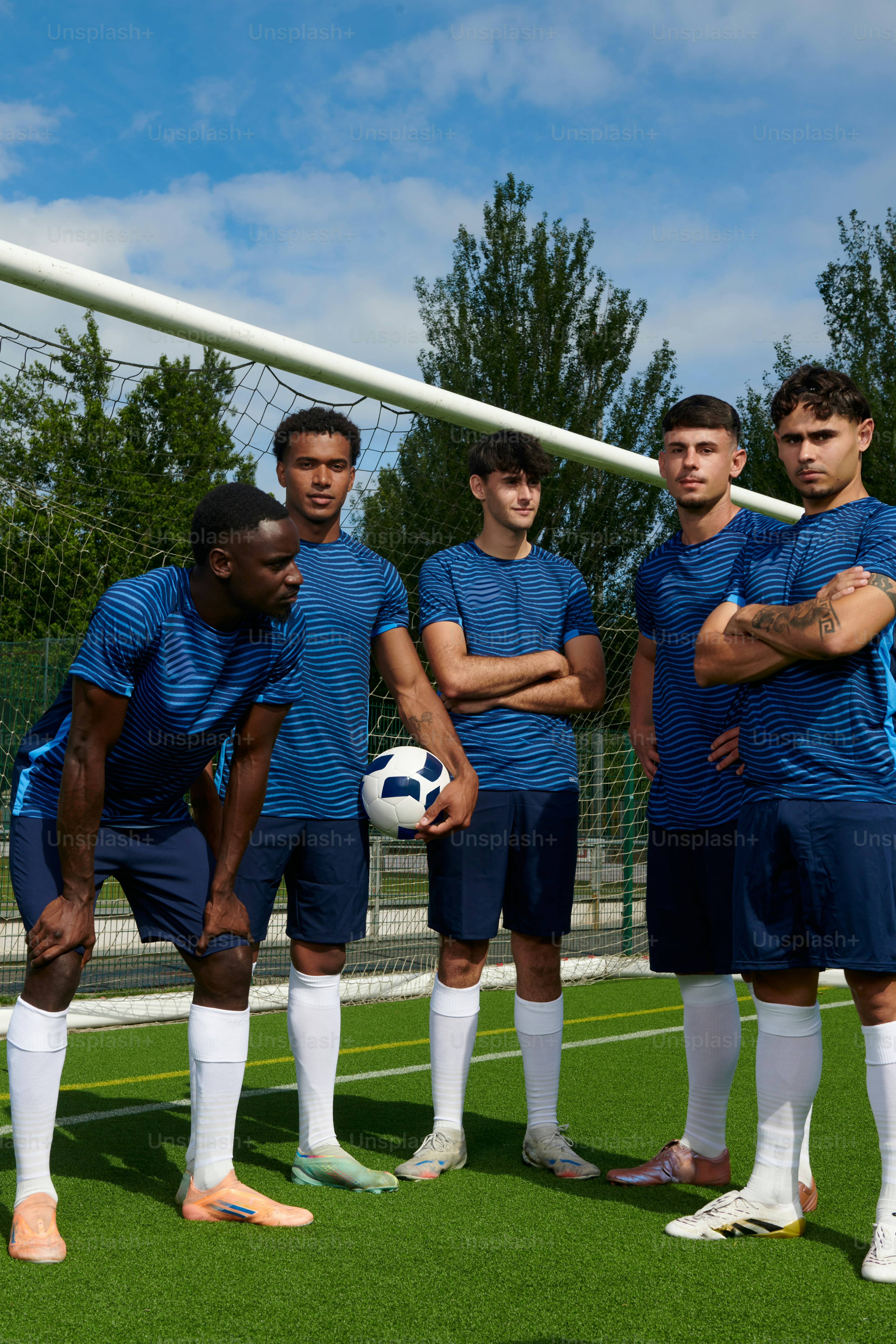Fünf Fußballspieler in blauen Trikots auf dem Spielfeld