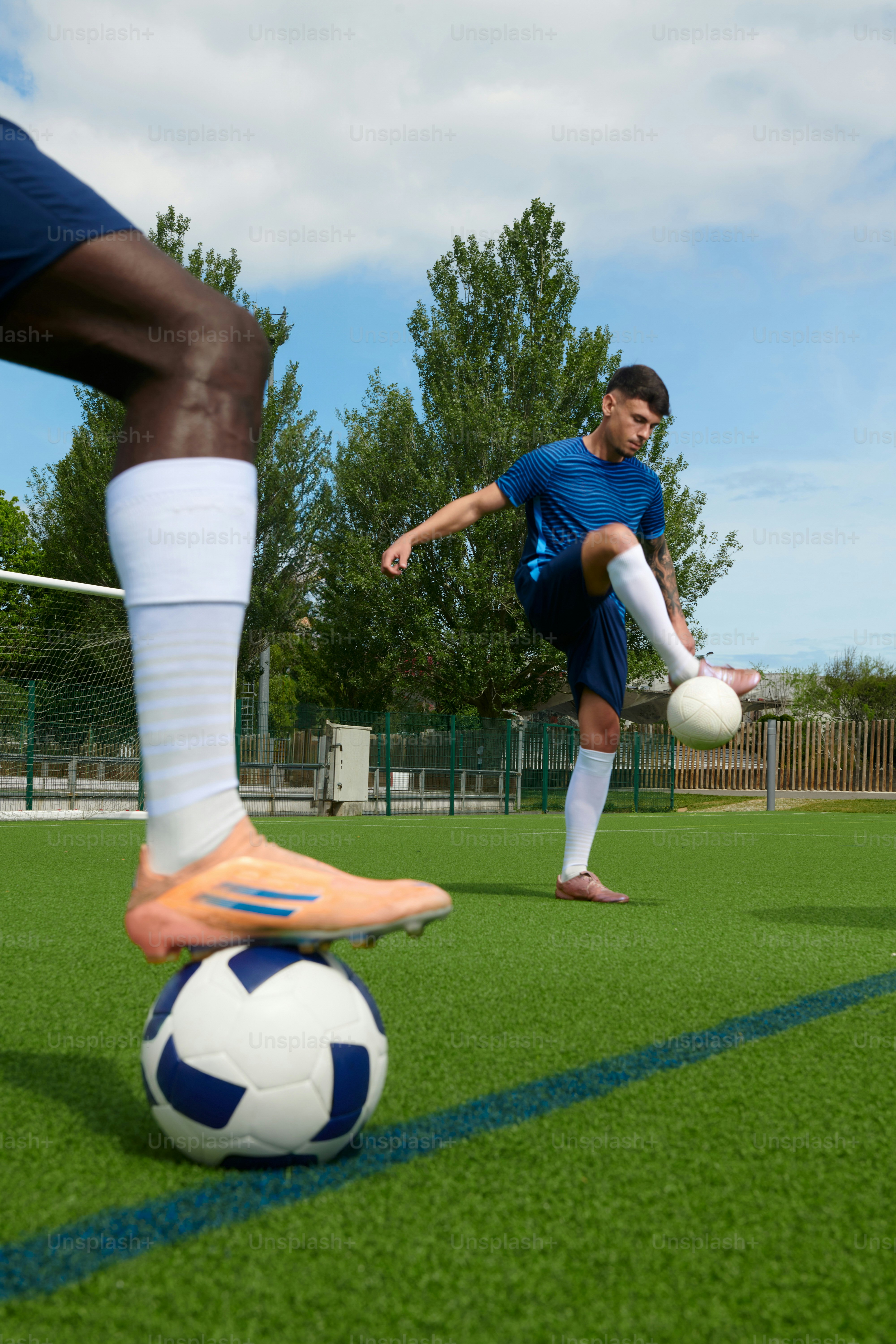 Fußballspieler, die mit Bällen auf Kunstrasen trainieren