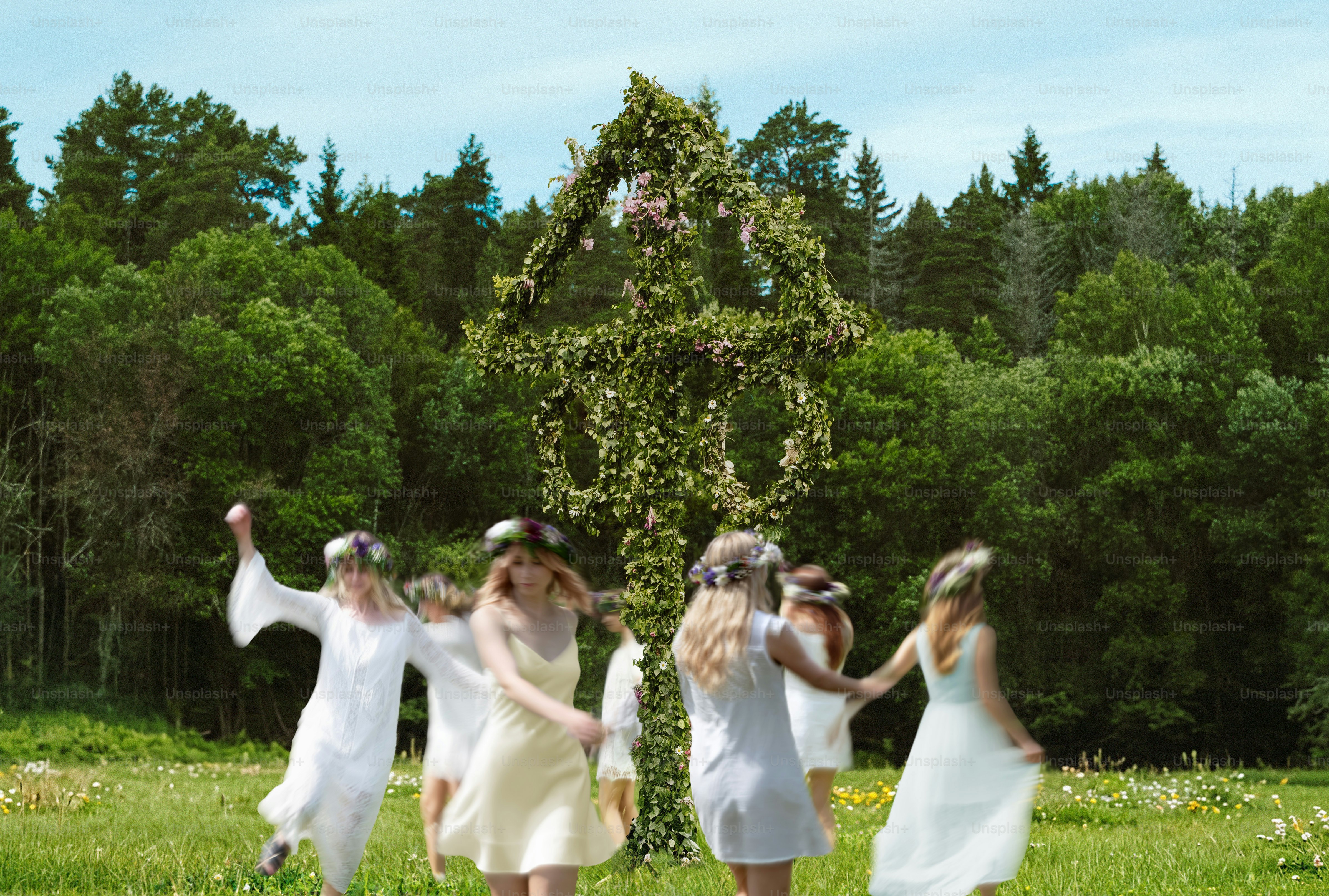 Joyful swedish midsummer dancing around a flower-covered pole