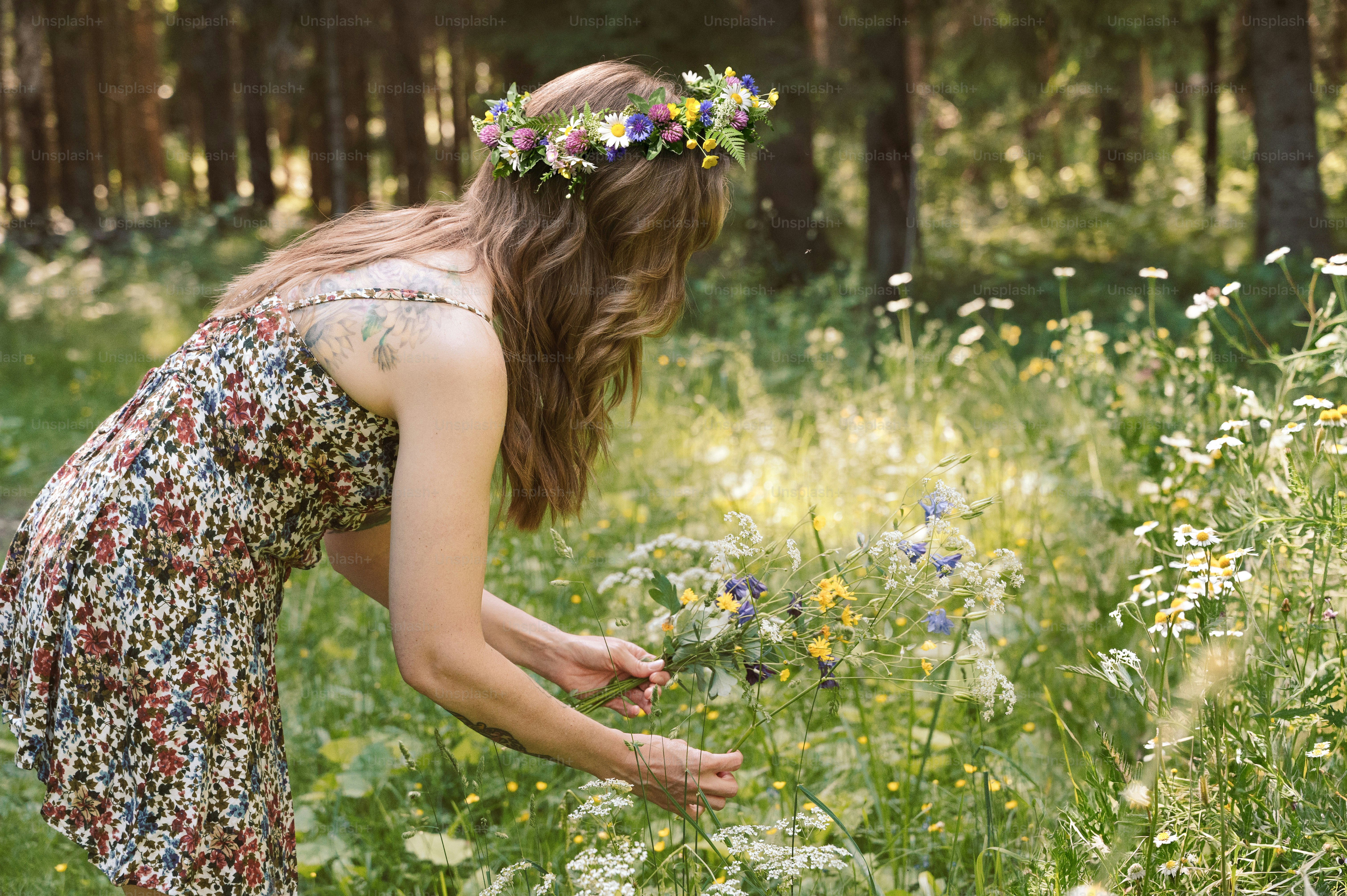 Frau sammelt Wildblumen für die Tradition im Mittsommer