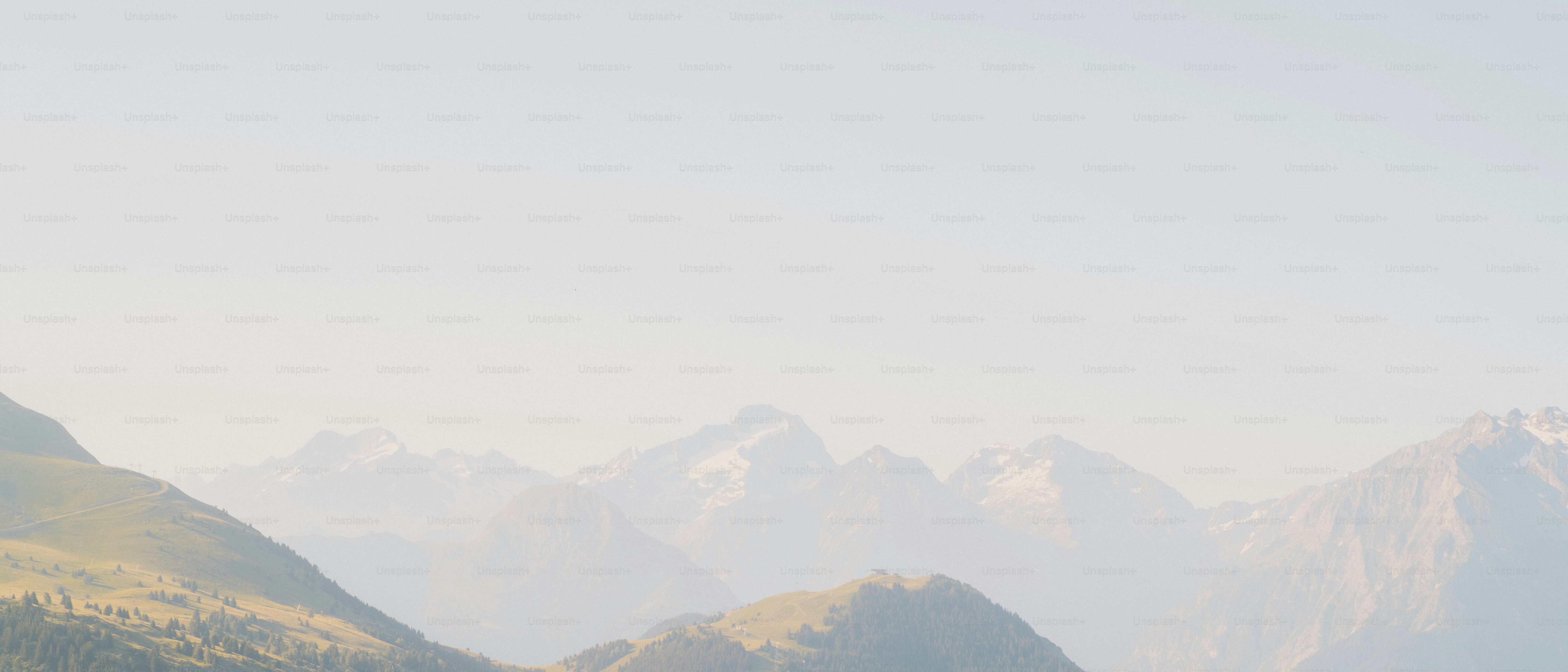 Paesaggio montuoso nebbioso con vette innevate lontane