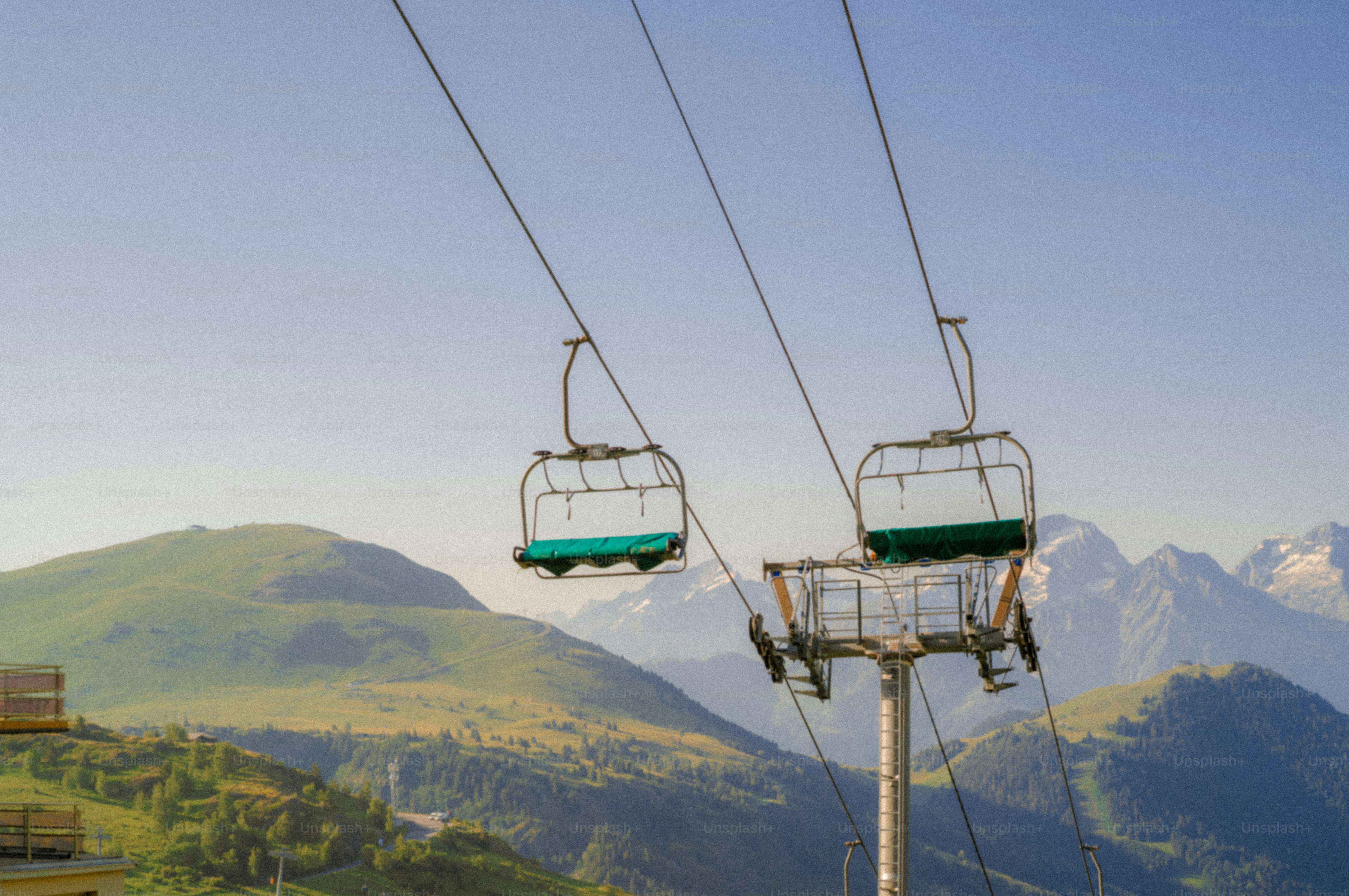 Empty chairlifts against a backdrop of mountains