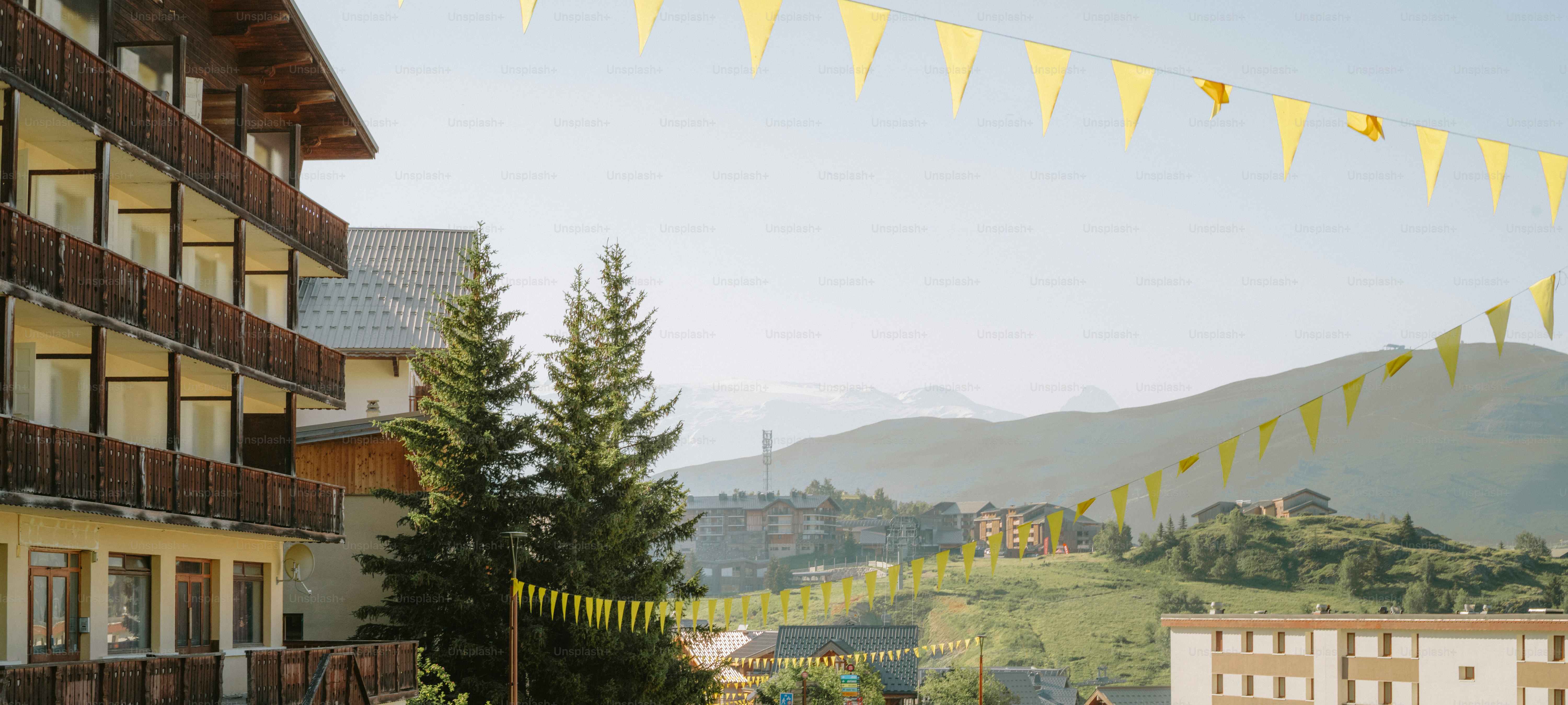 Building with balconies, yellow flags, mountain landscape