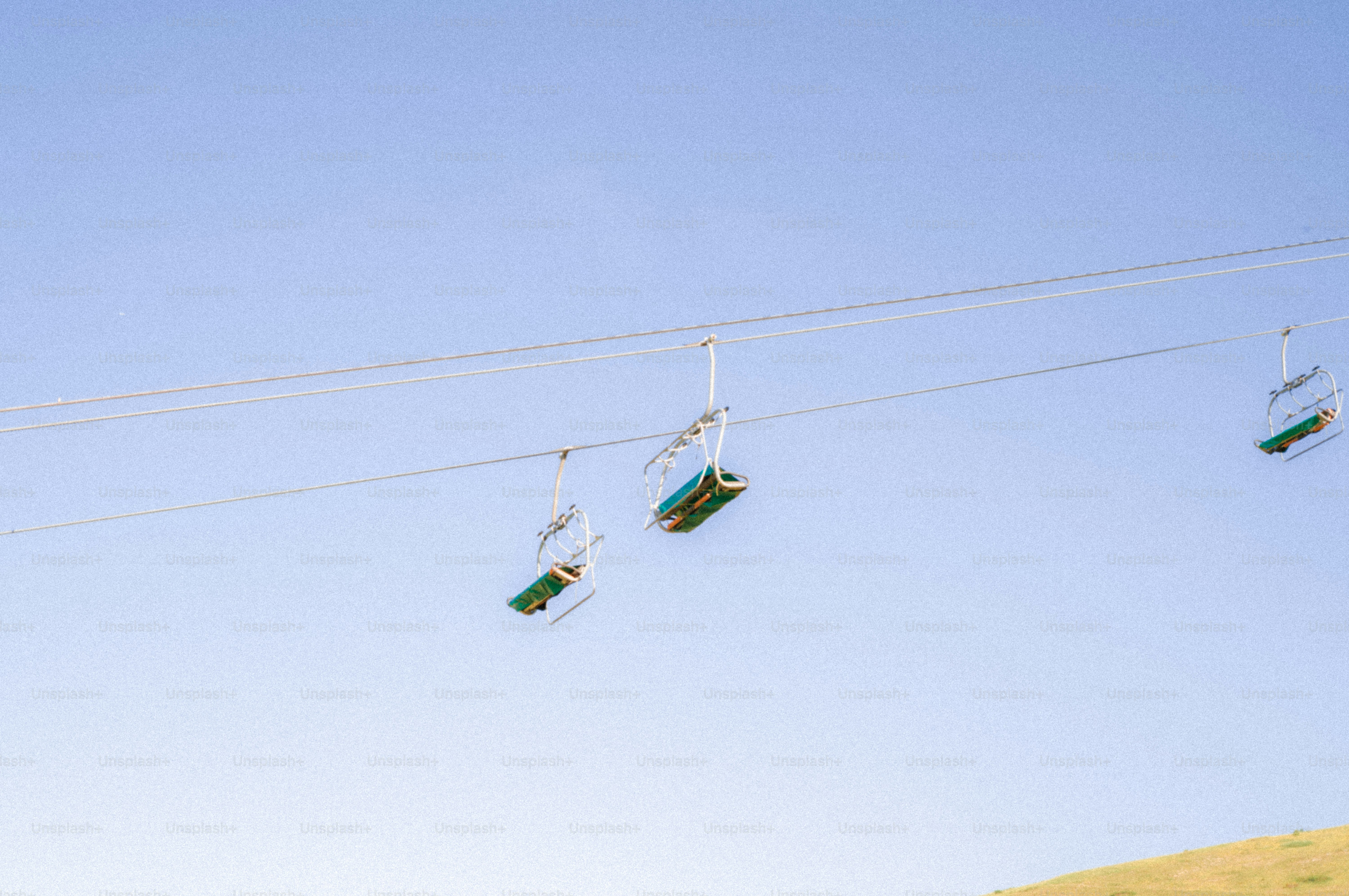 Empty ski lift chairs under a blue sky