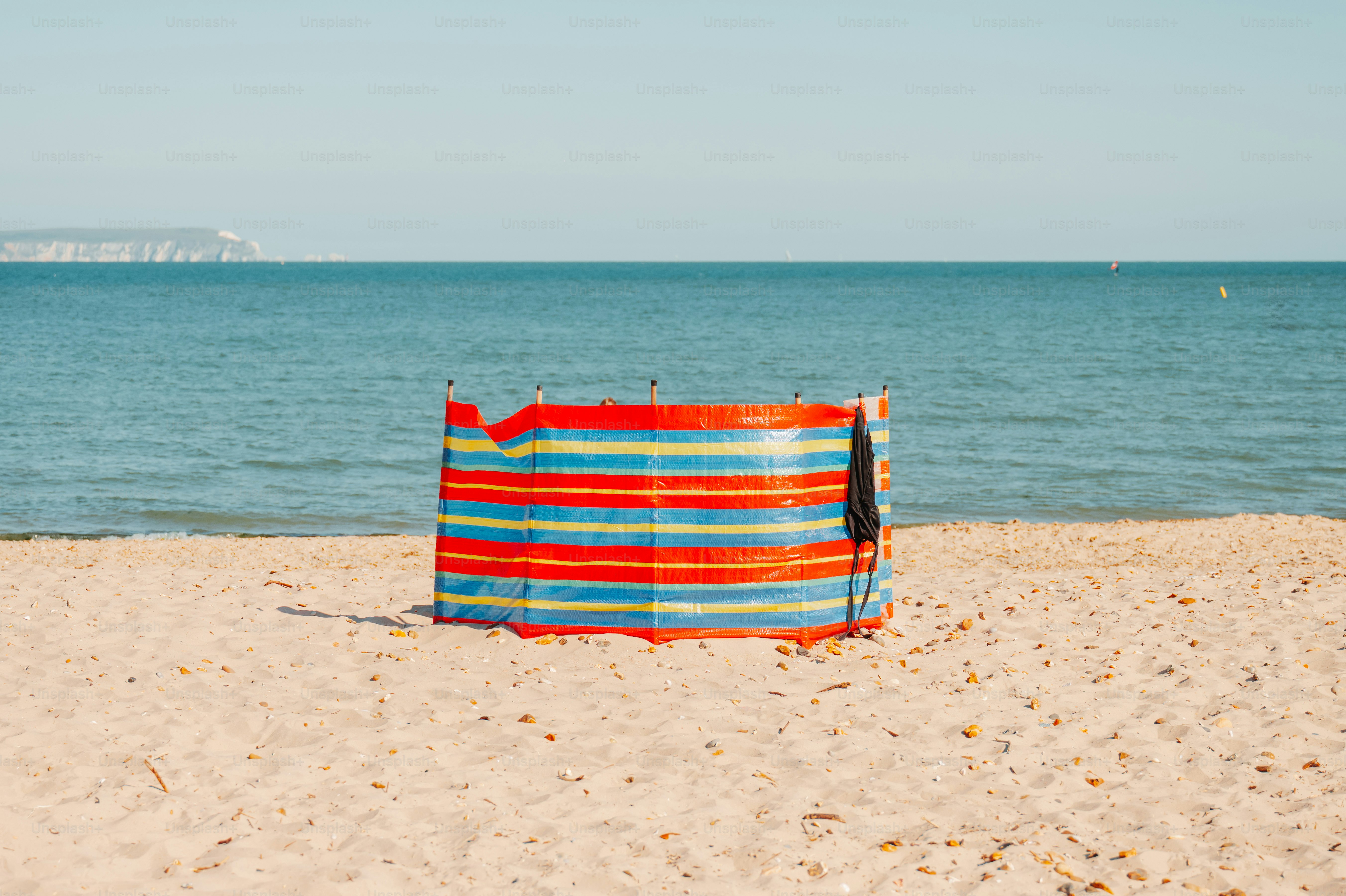 Striped windbreak on a sandy beach by the ocean