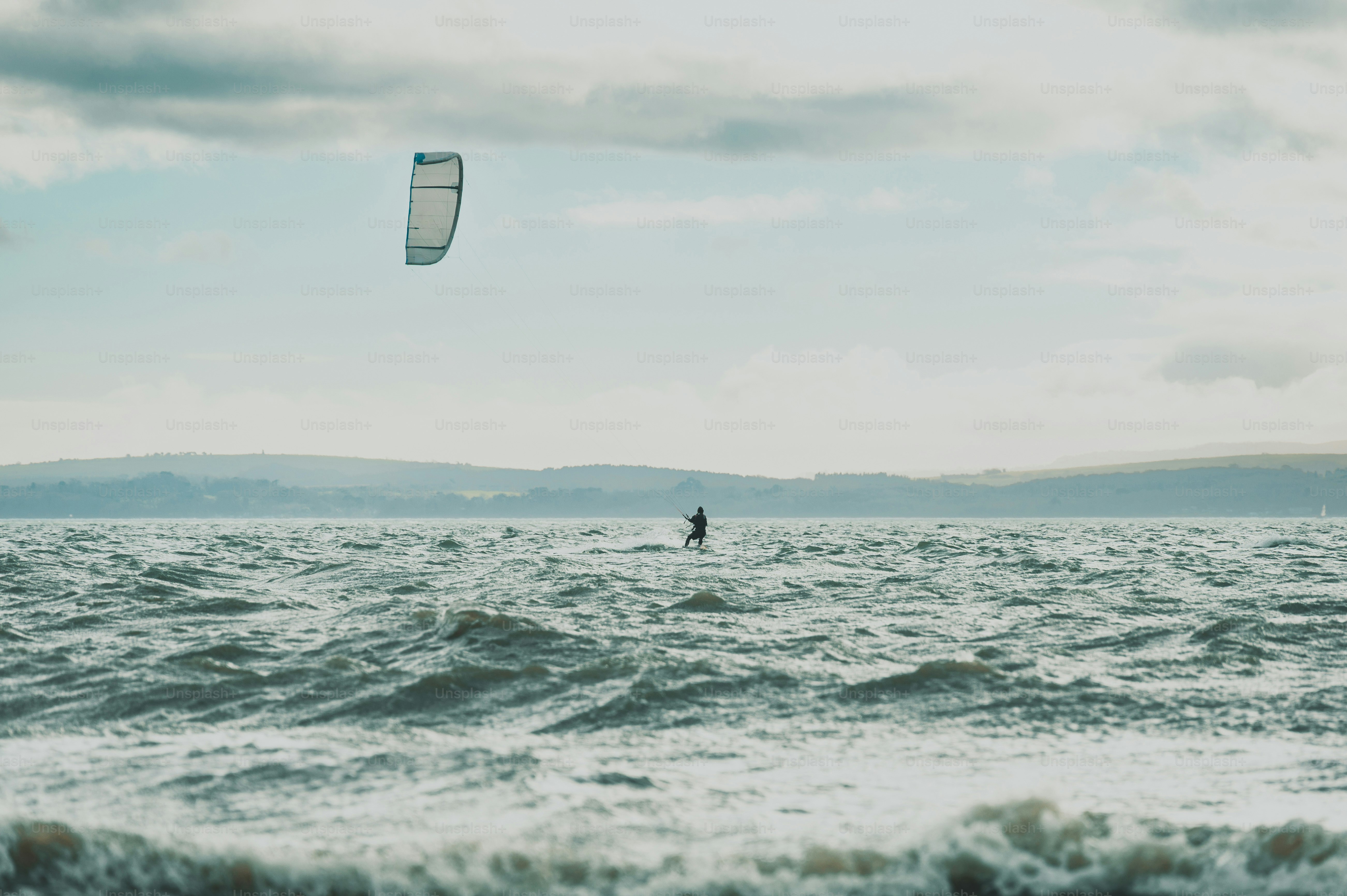 Kitesurfer on choppy water under cloudy sky