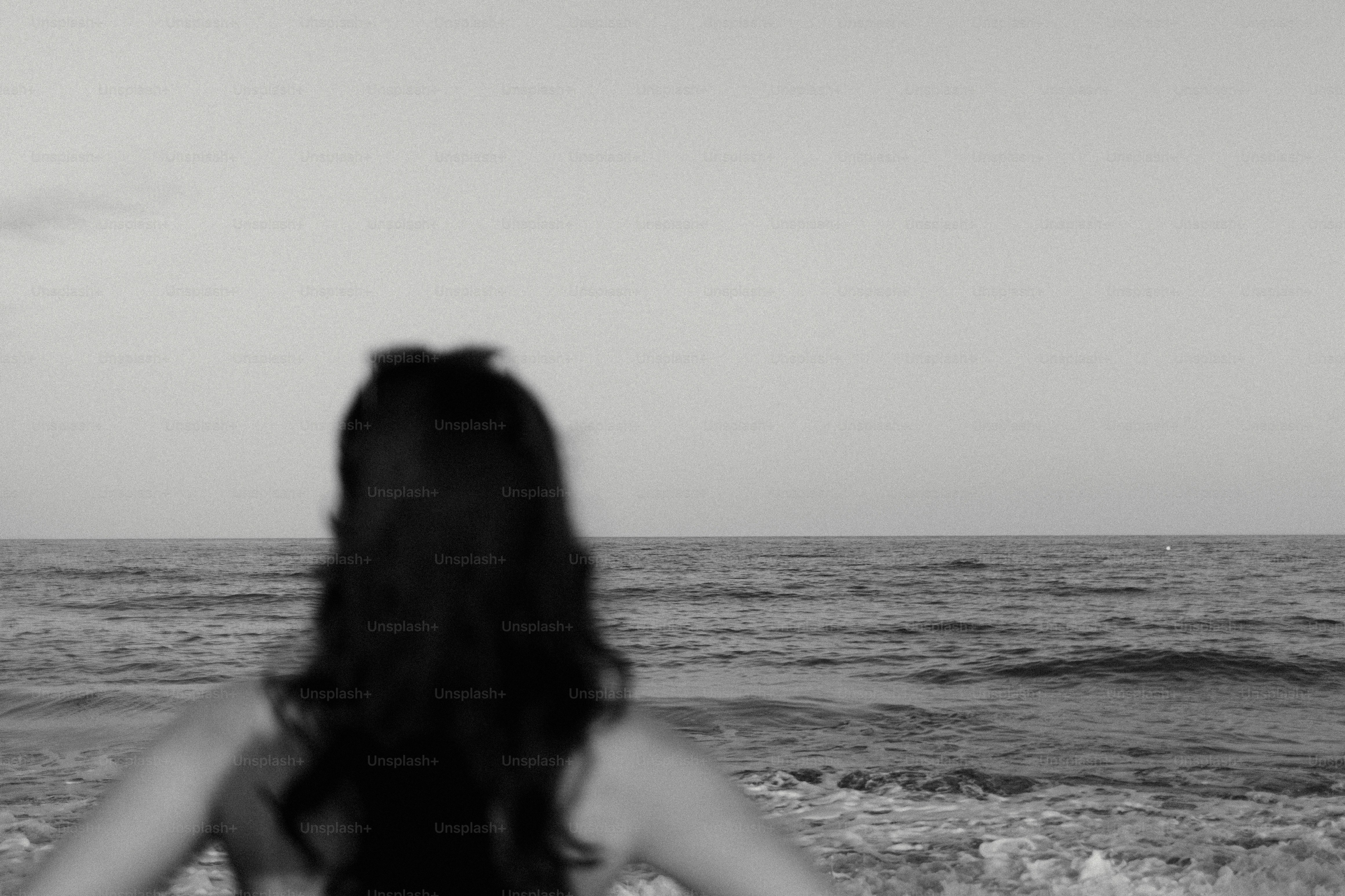 海の地平線を見つめる女性