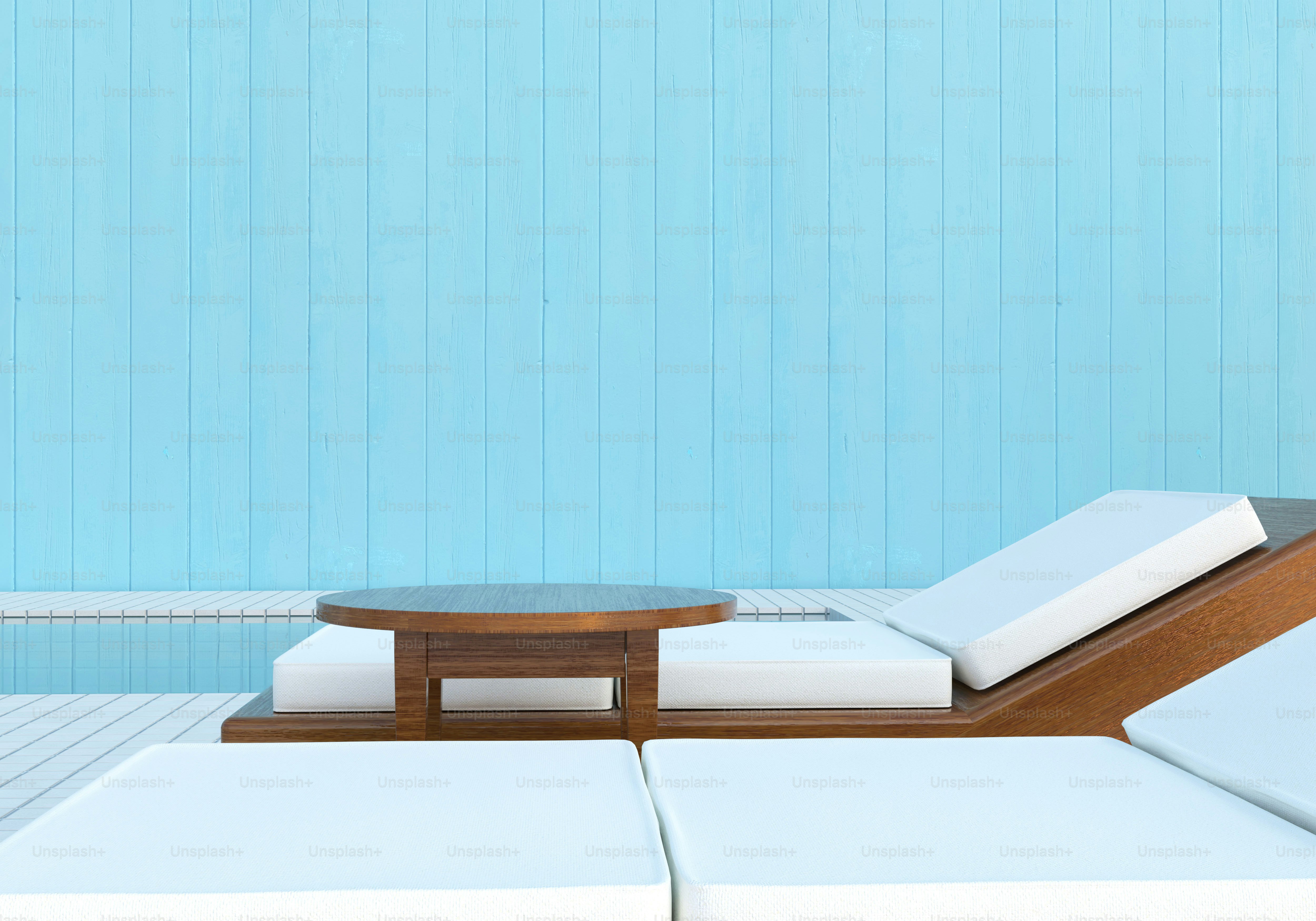 White lounge chairs and table by swimming pool