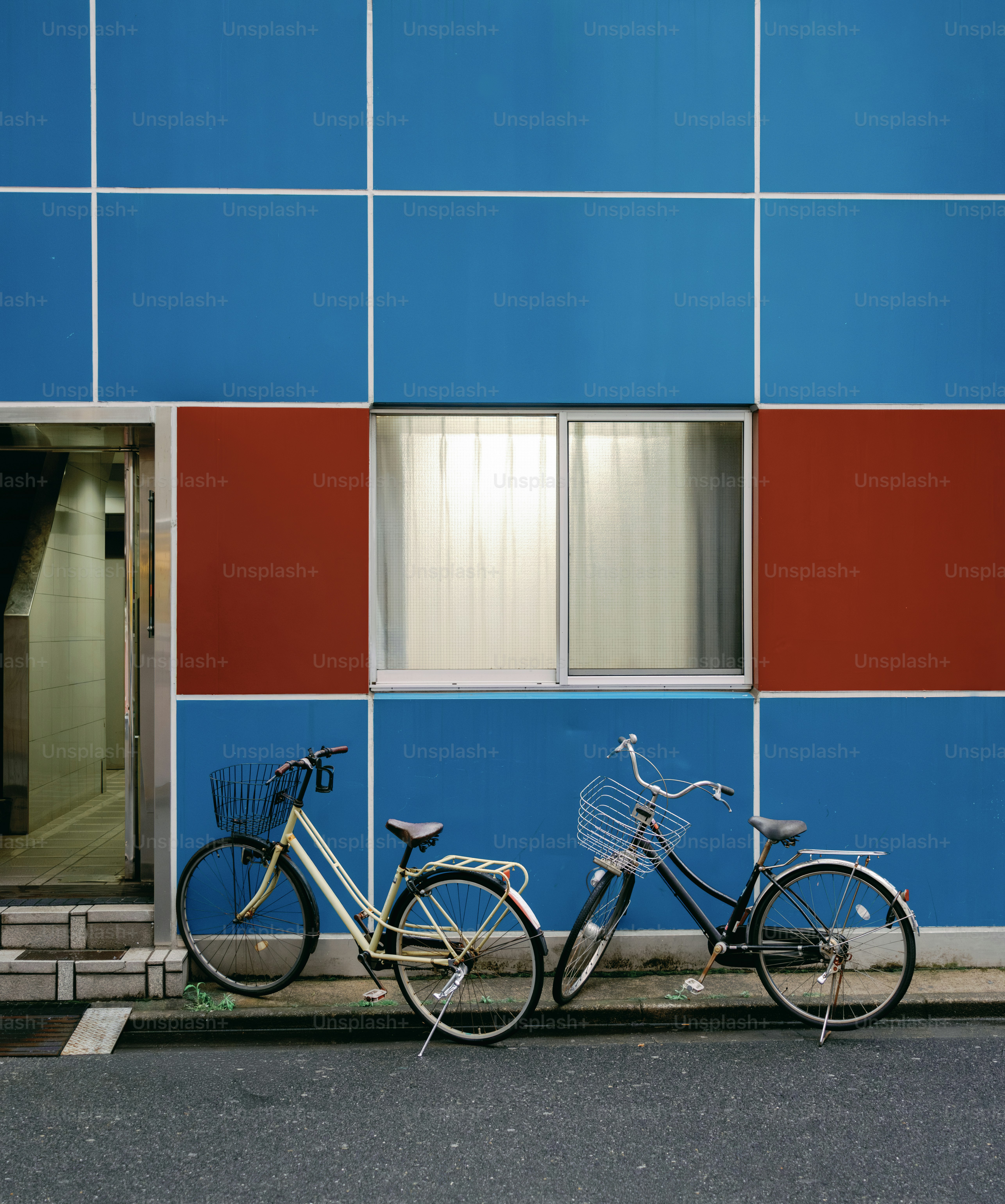 Due biciclette parcheggiate contro una colorata facciata di un edificio