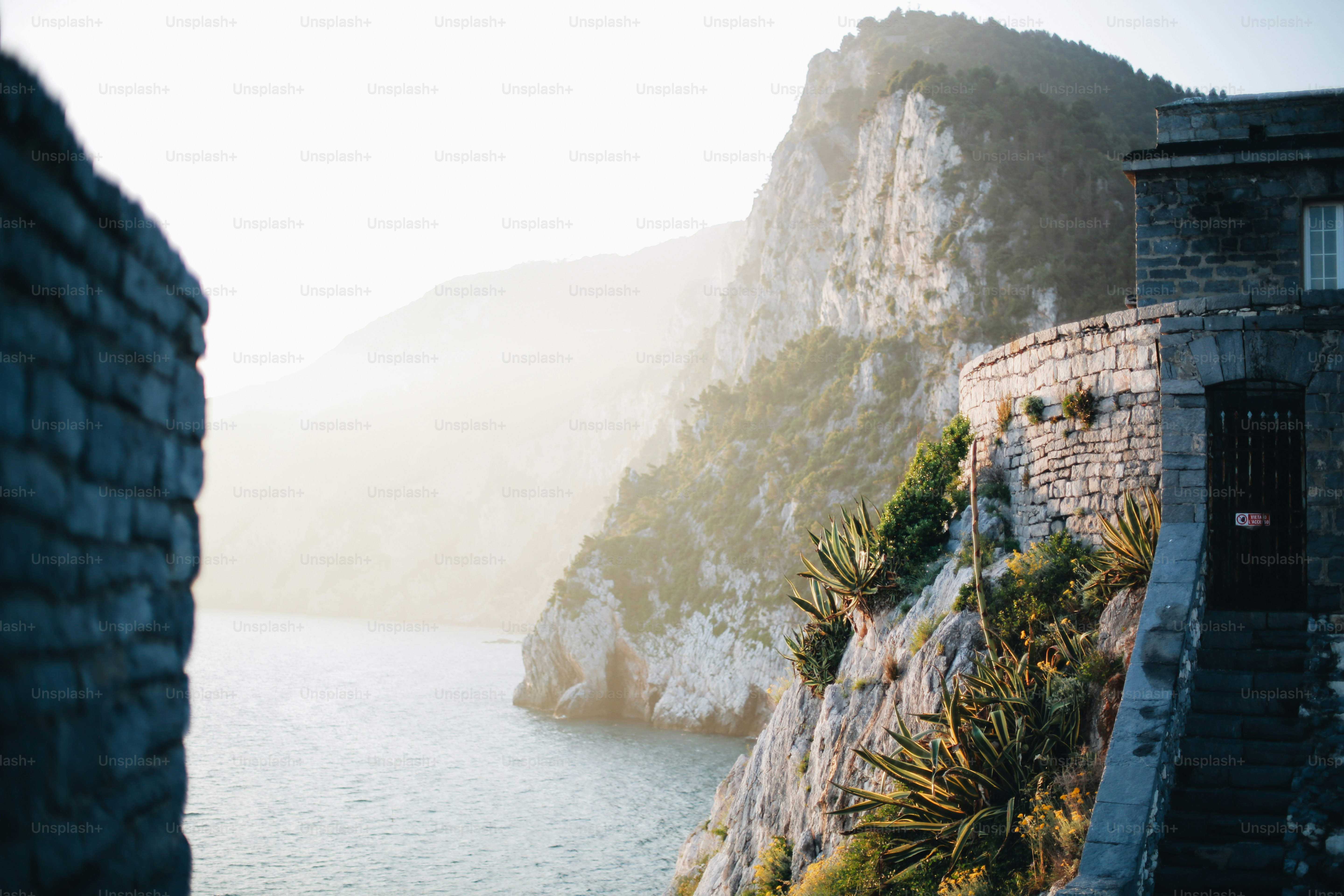 Old stone building on cliff above hazy ocean