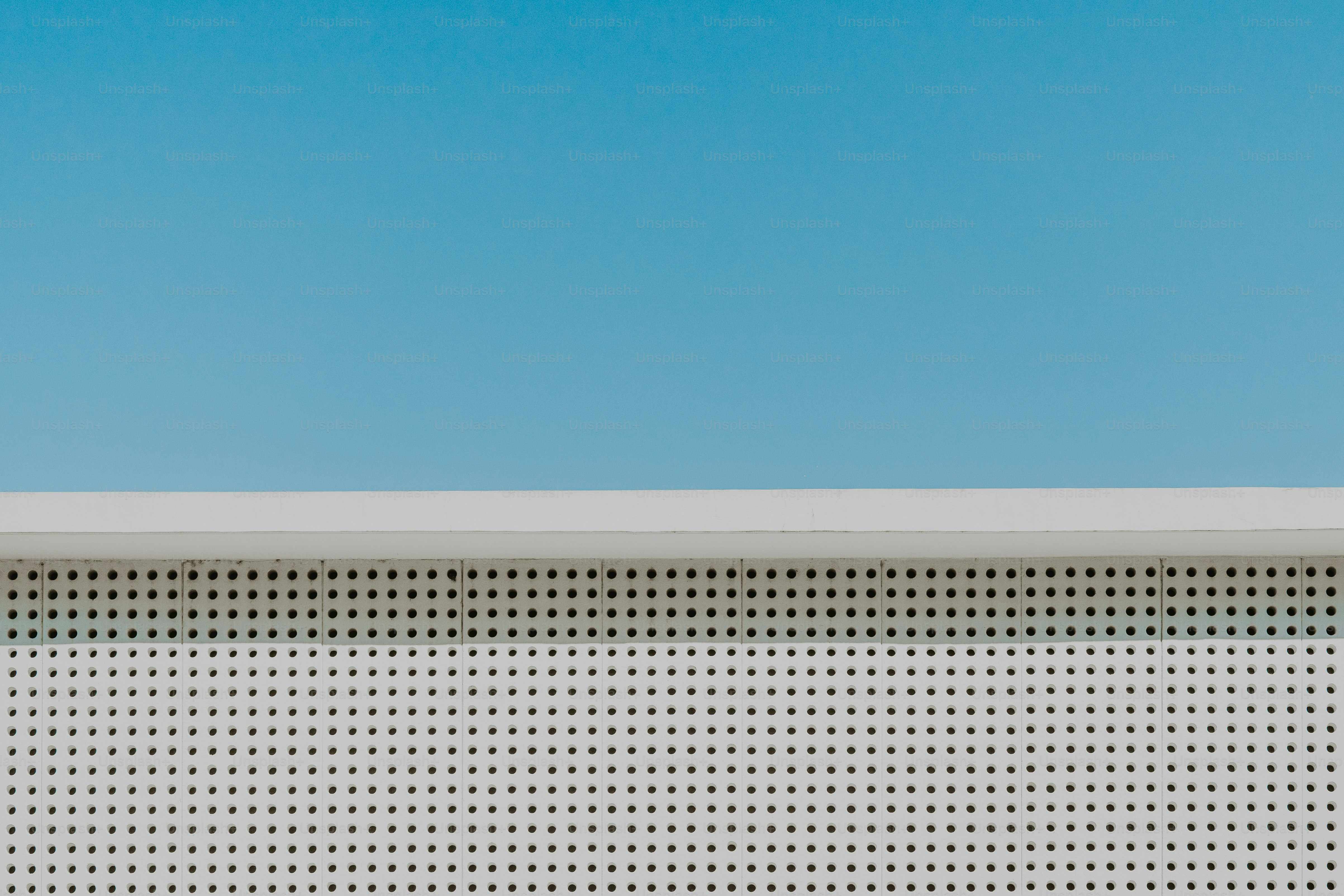 Minimalistischer blauer Himmel und weiße perforierte Oberfläche