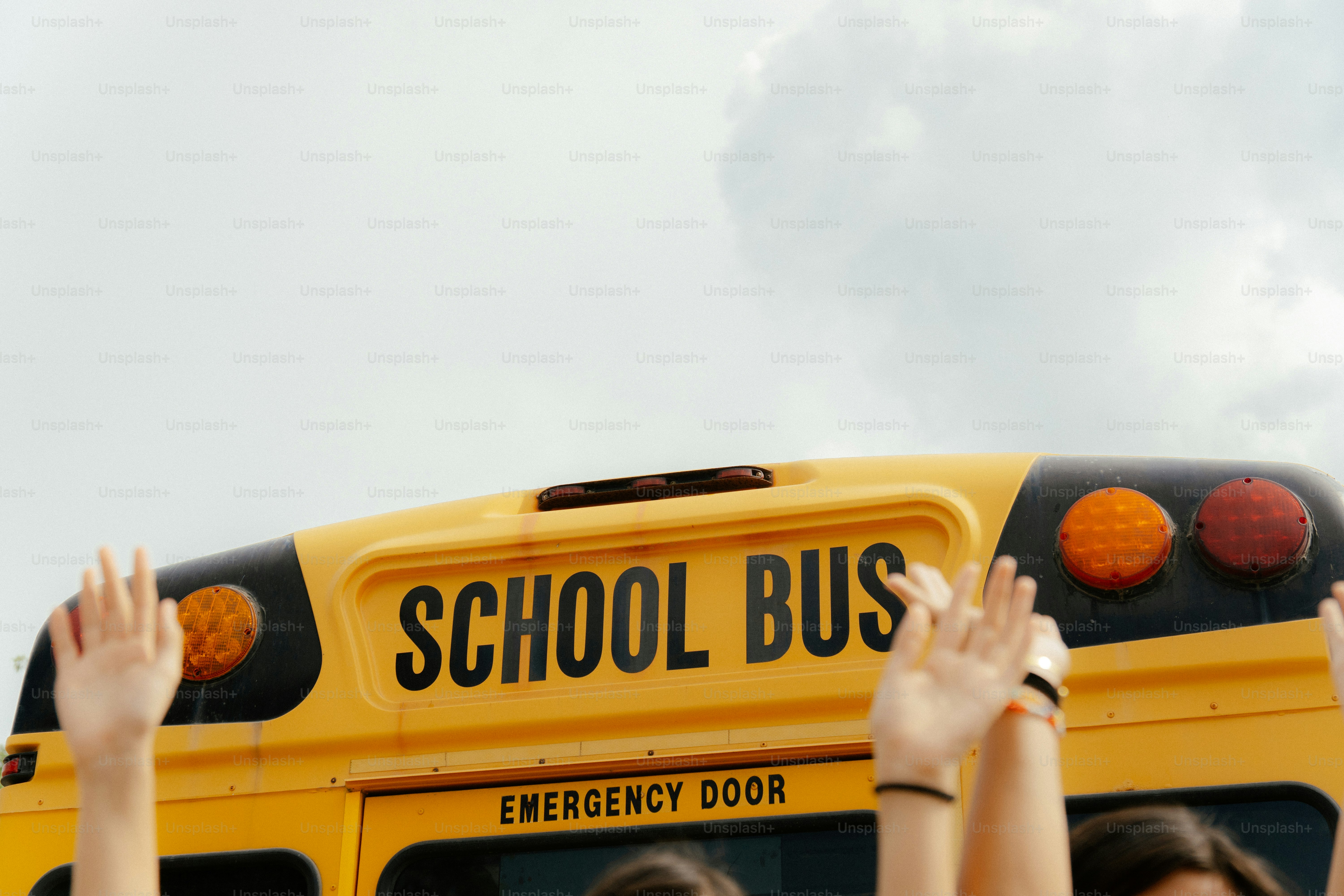 Hands raised in front of school bus