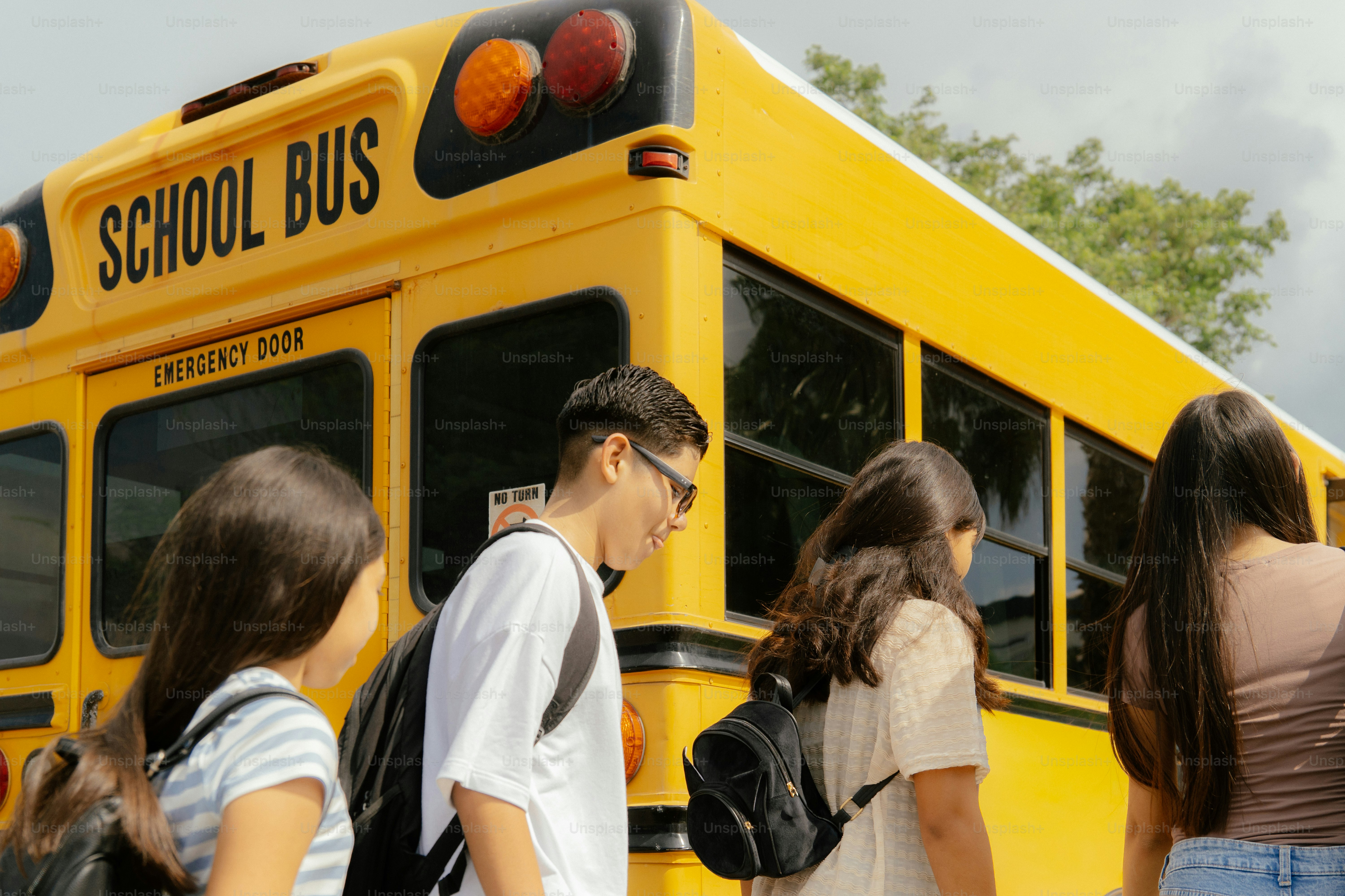 Students walking towards a yellow school bus