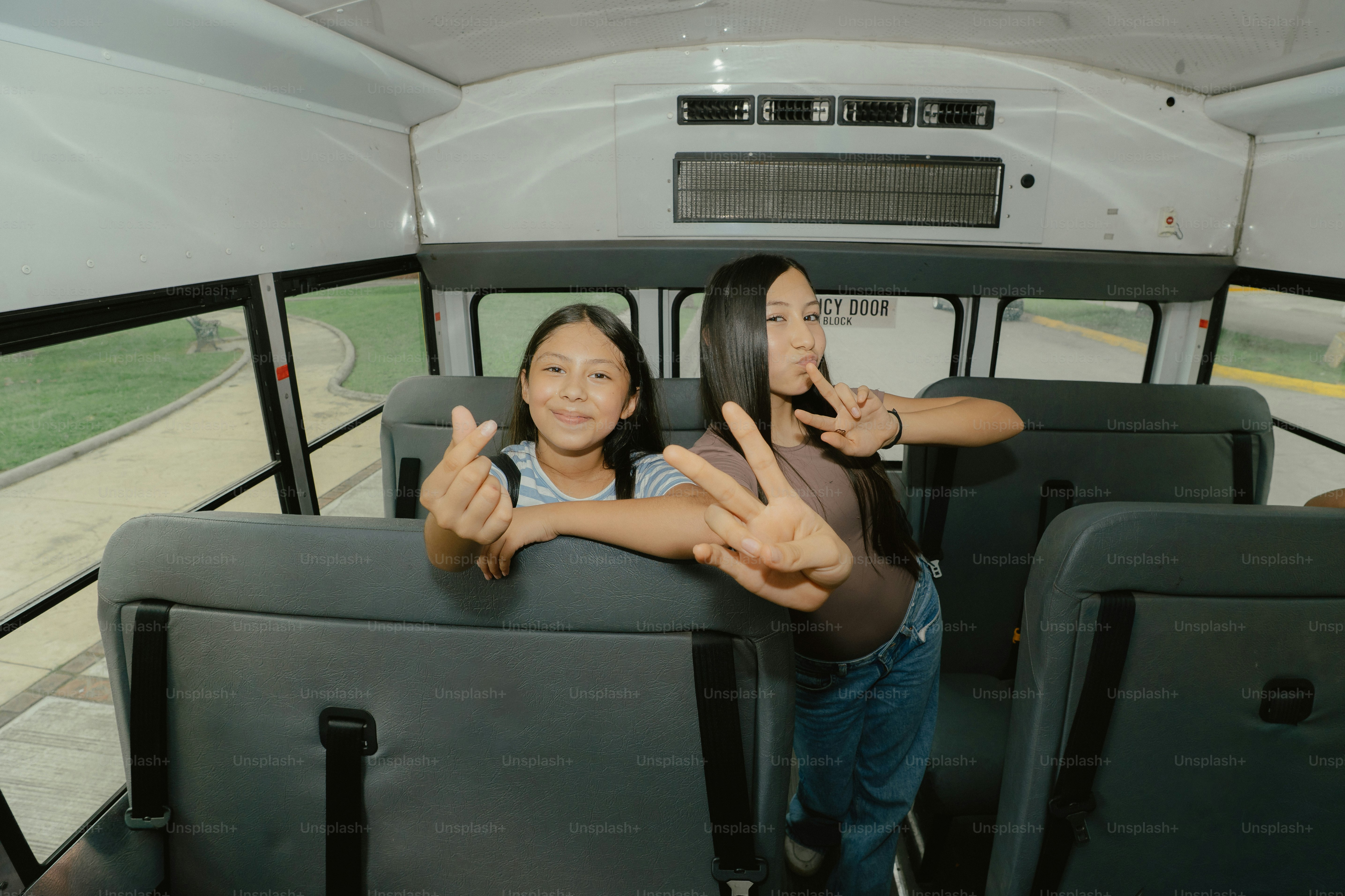 Girls making peace and heart signs in a bus