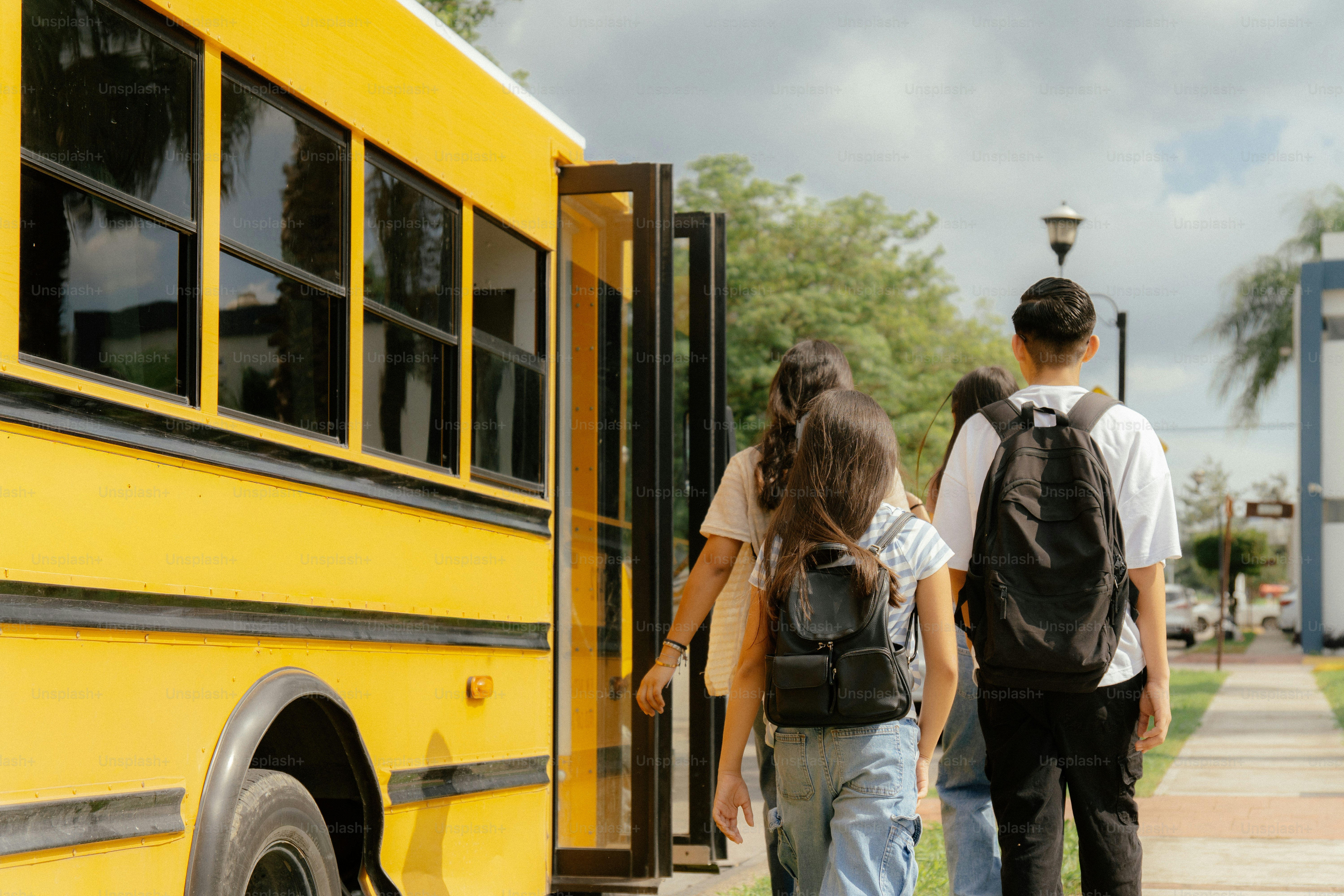 Students with backpacks boarding yellow school bus