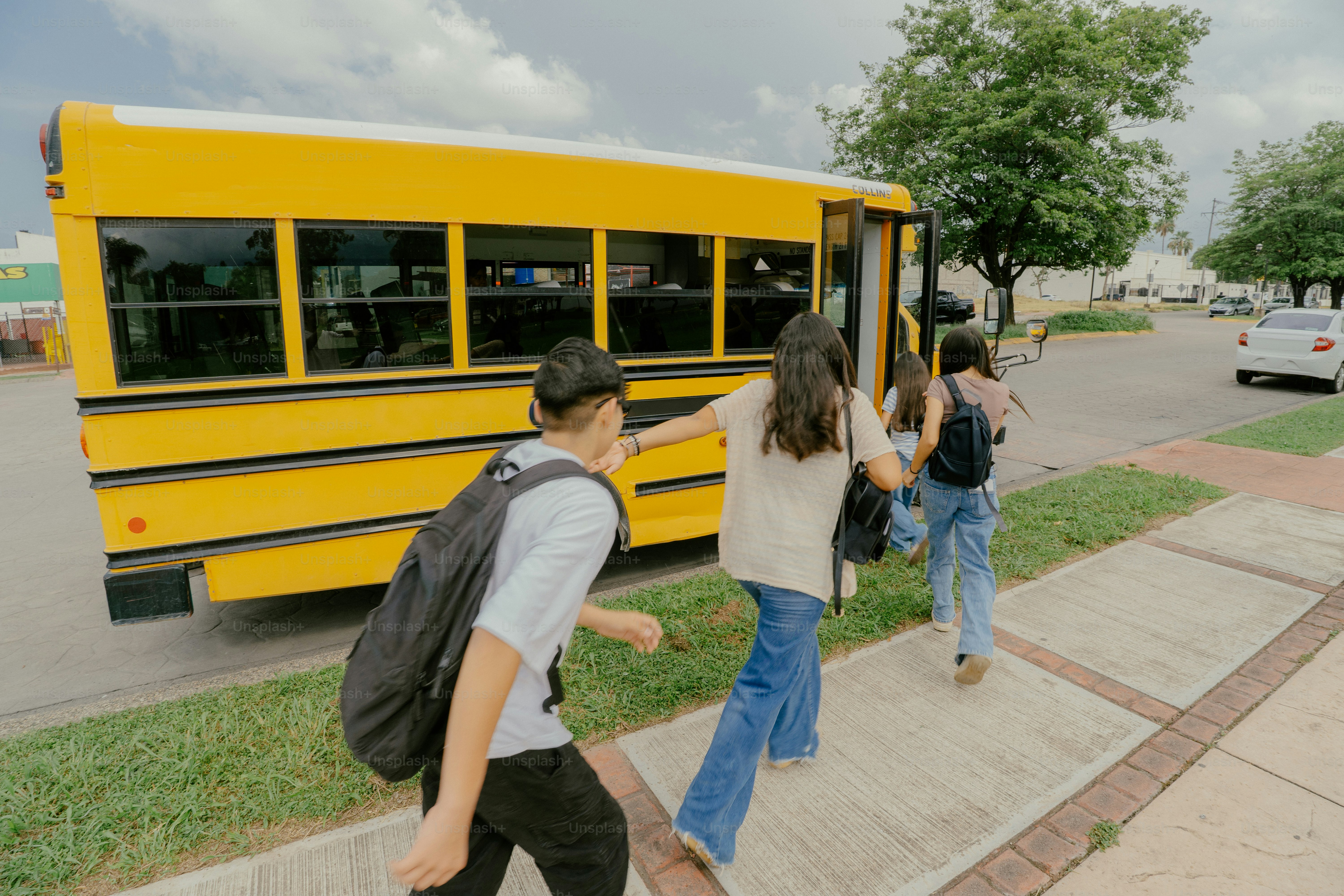Students with backpacks boarding a yellow school bus