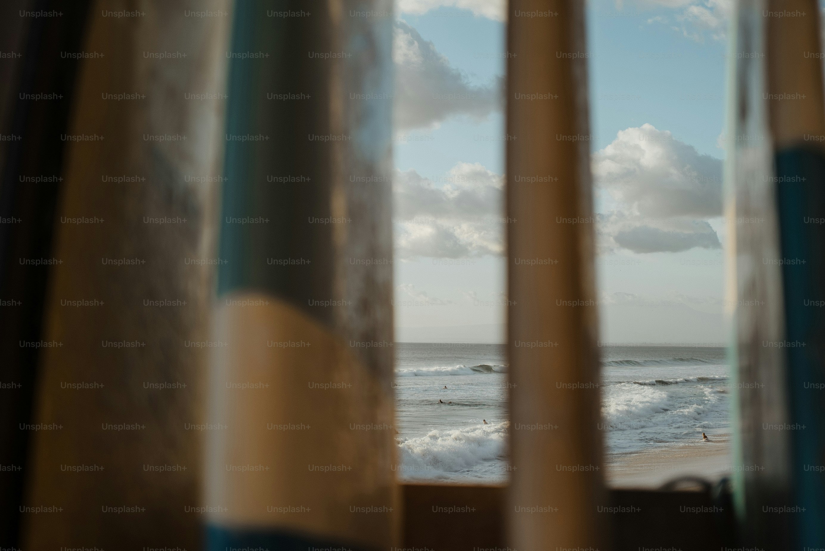 Ocean waves viewed through row of surfboards